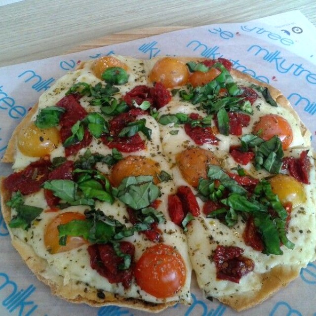 pizza capri con tomates secos, tomates cherry, albahaca y queso mozzarella