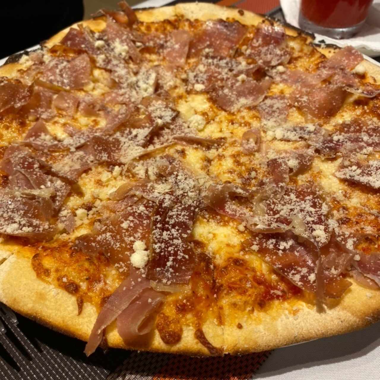 Pizza de jamón serrano, parmesano y rúcula