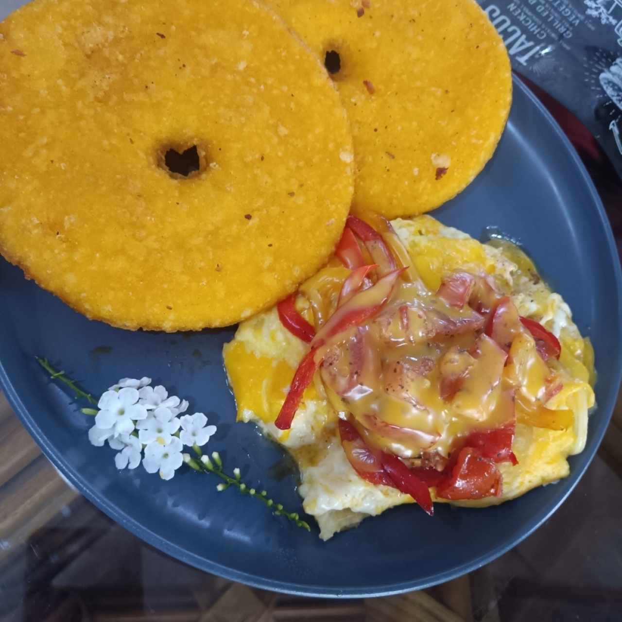 Huevos Revuelto con queso amarillo y vegetales acompañado de tortilla de maiz.