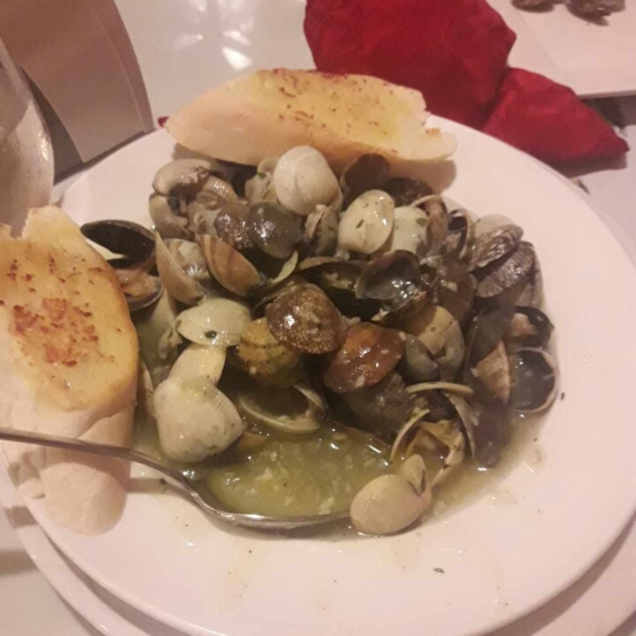 Almejas en su concha al ajillo acompañadas de pan con mantequilla
