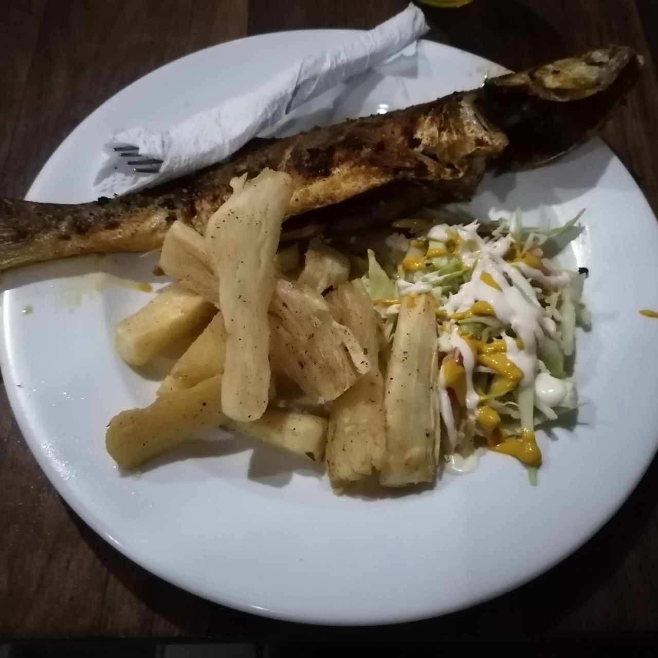 Yuca frita con pescado frito y ensalada. 