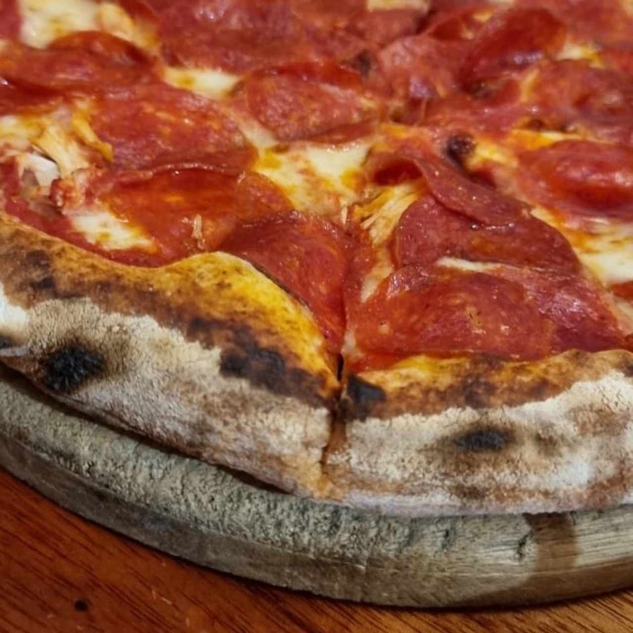 pizza de peperoni en fuego de leña 