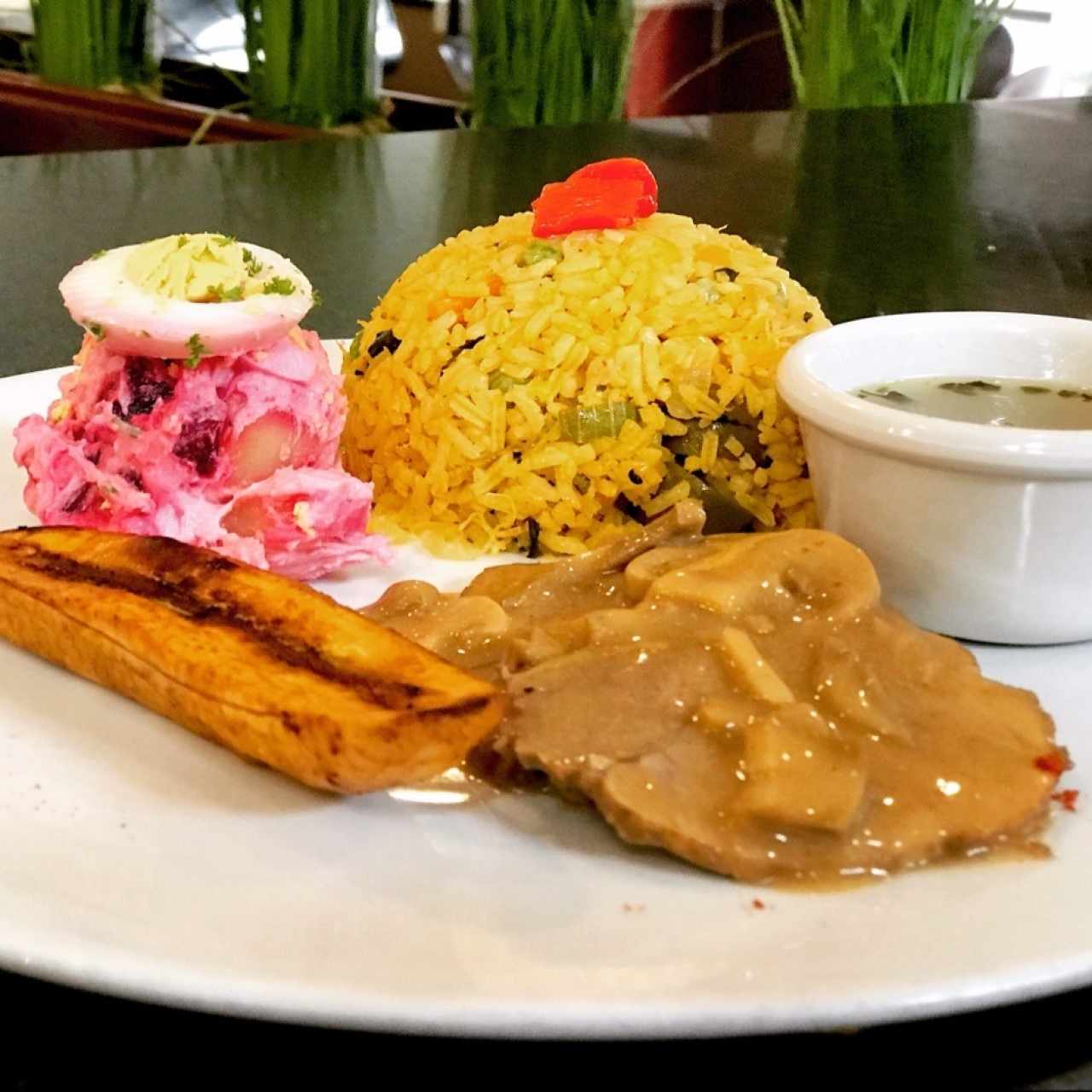 una rica comida criolla con arroz con pollo, lomo en champiñones, ensalada de papas y sancochito