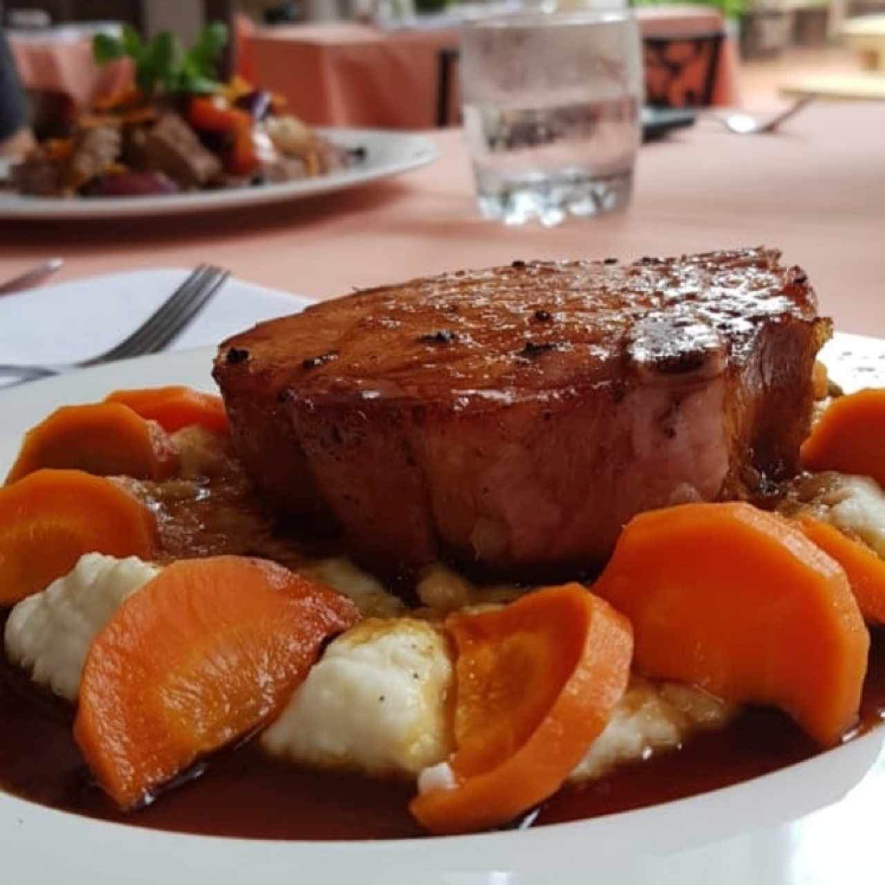 Chuleta de Cerdo Ahumada al grill, con miel de caña dulce y puré de ñame con rodajas de zanahoria