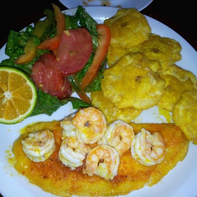 Filete de corvina en salsa de camaron con patacones y ensalada verde.