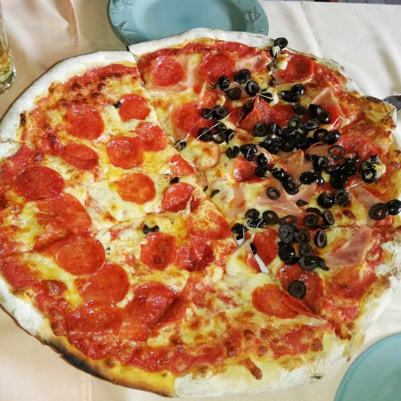 Pizza de peperoni, jamón y aceitunas