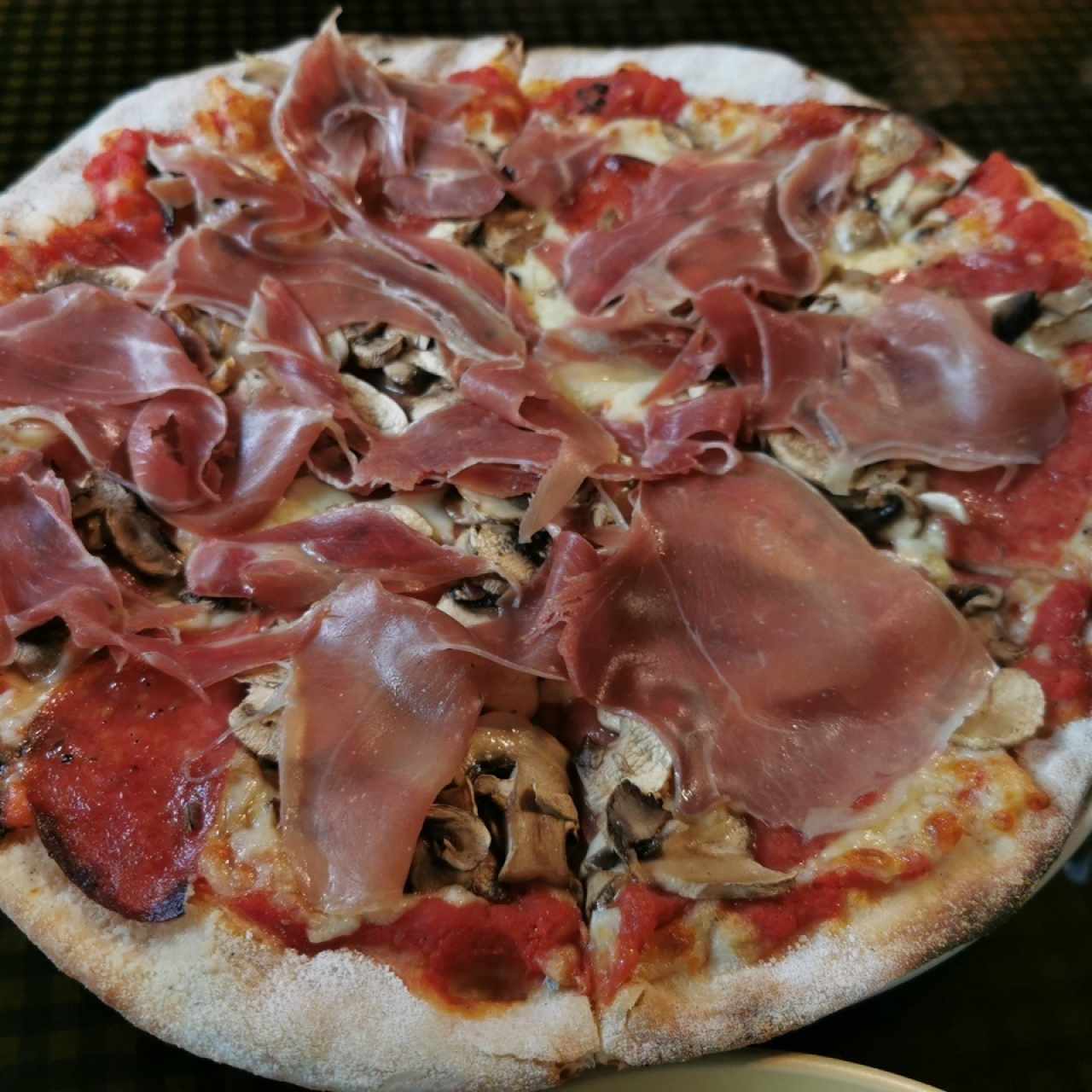 Pizza con prosciutto, salami italiano, queso mozzarella y salsa de tomate