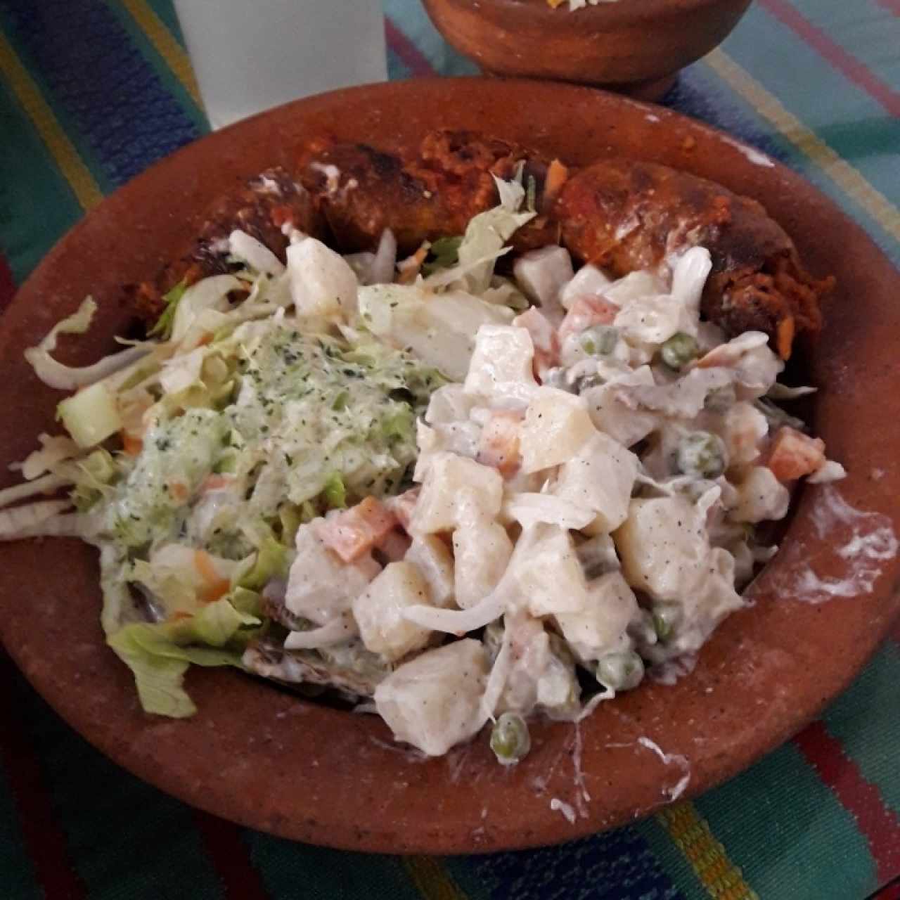 Chorizo, acompañado de ensalada rusa, ensalada de vegetales y arroz.