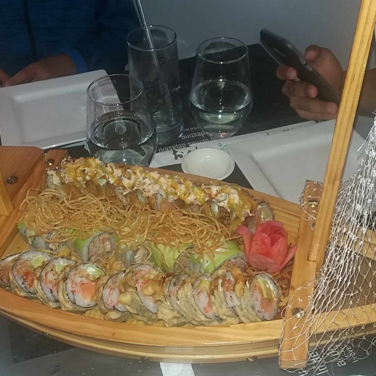 3 tipos de rollos sushi servidos en un barquito