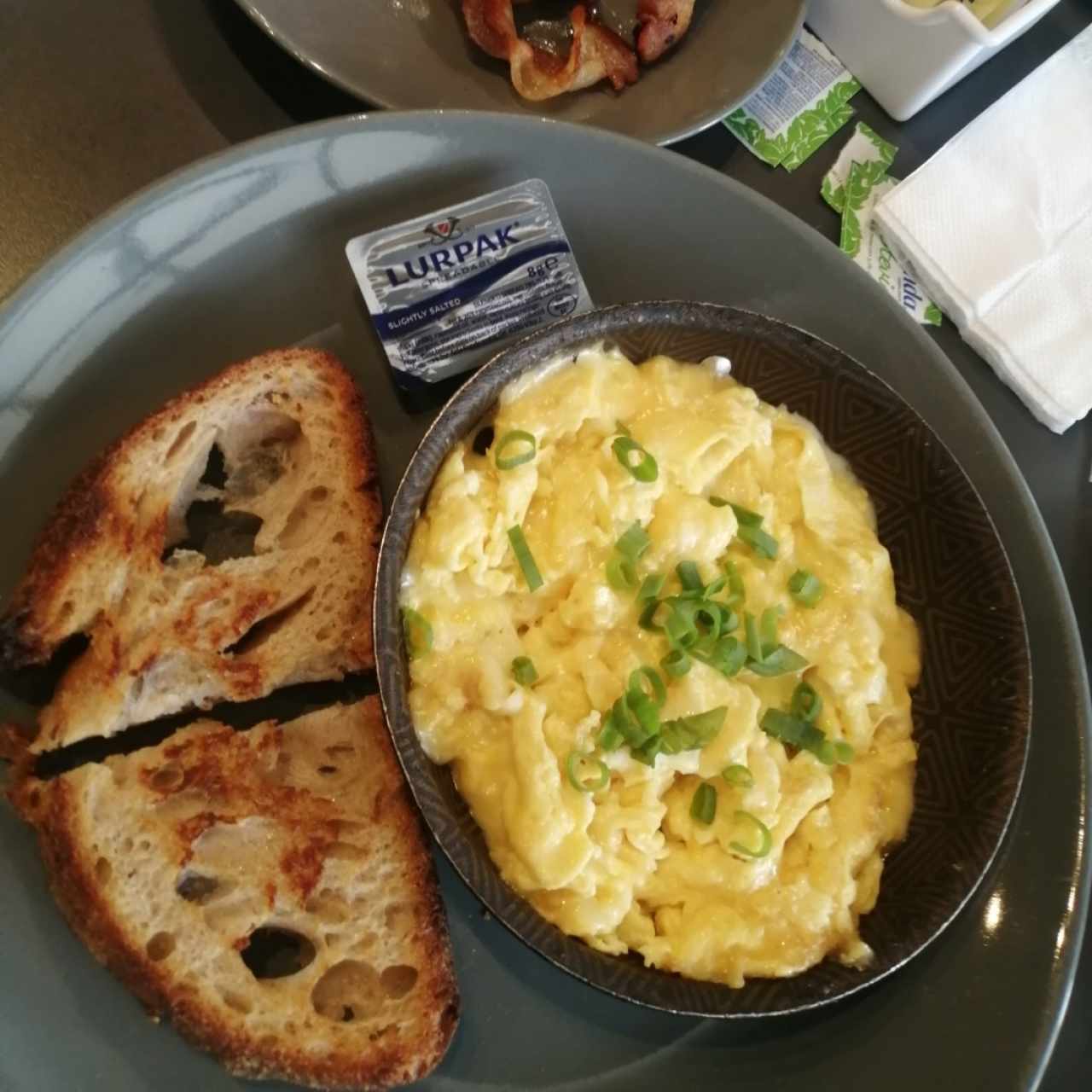 huevos revueltos con queso y con pan de la casa y extra tocino