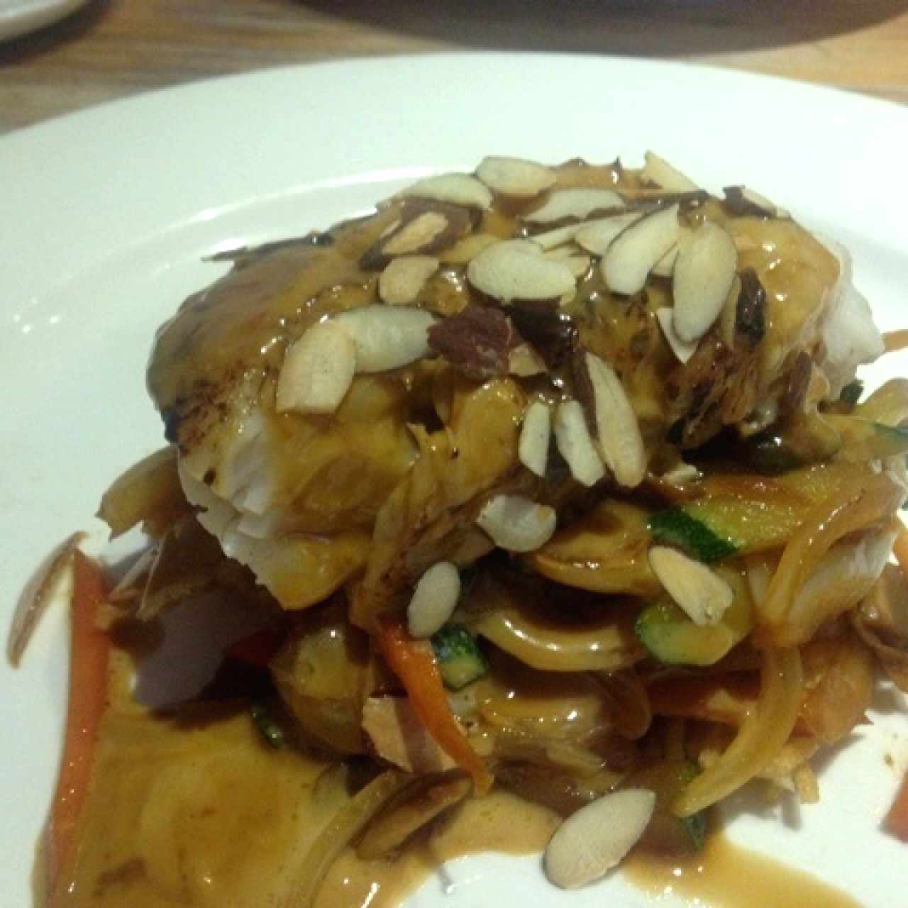 corvina con fideos fritos y vegetales en salsa teriyaki