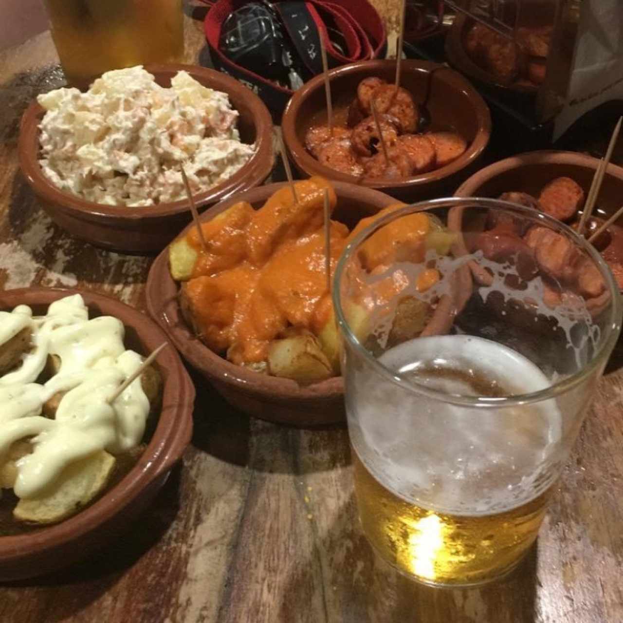 Tapas, ensaladilla rusa, chorizo al infierno, papas bravas y alioli 