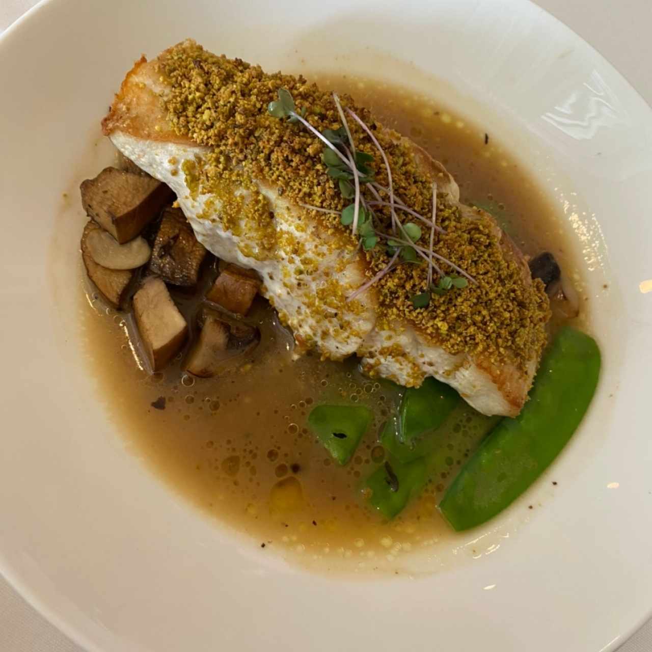 Pesca del día en costra de pistacho, champiñones fresco y emulsión de beurre noisette con sabor a trufa de verano