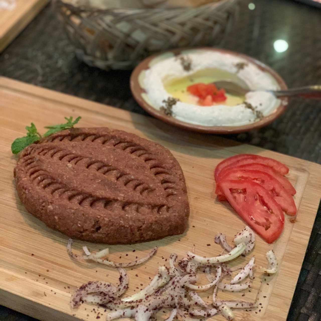 Kafta naye (carne cruda con cebolla y perejil). Atrás: Labne con ajo