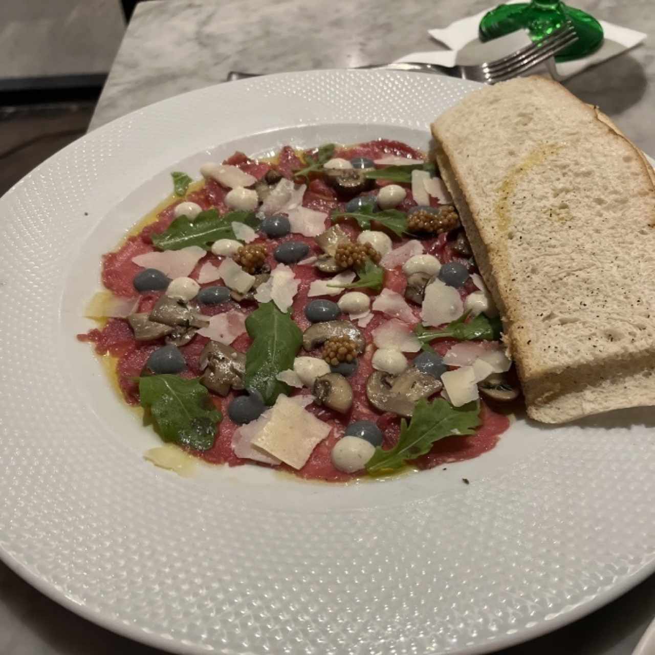 Carpaccio de Res, Creminis Asados, Parmesano D.O.P., y Mayonesa de Trufa Negra