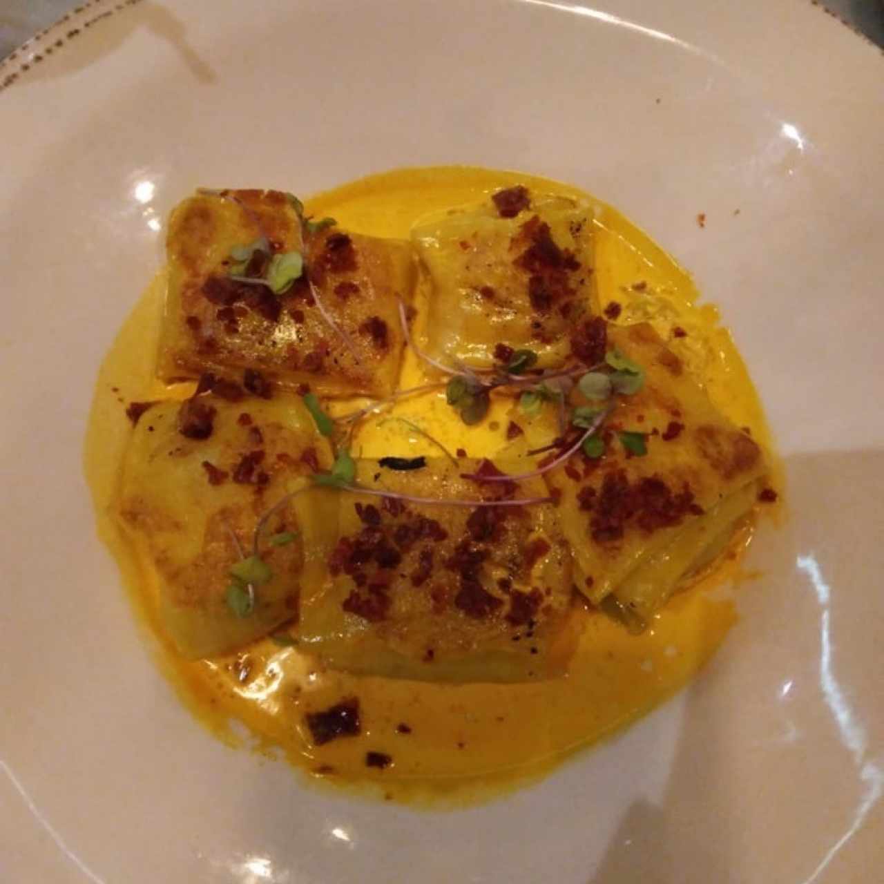 Ravioli Rellenos de Langosta, Jamón Serrano, Puerro Confitados y Espuma de Azafrán