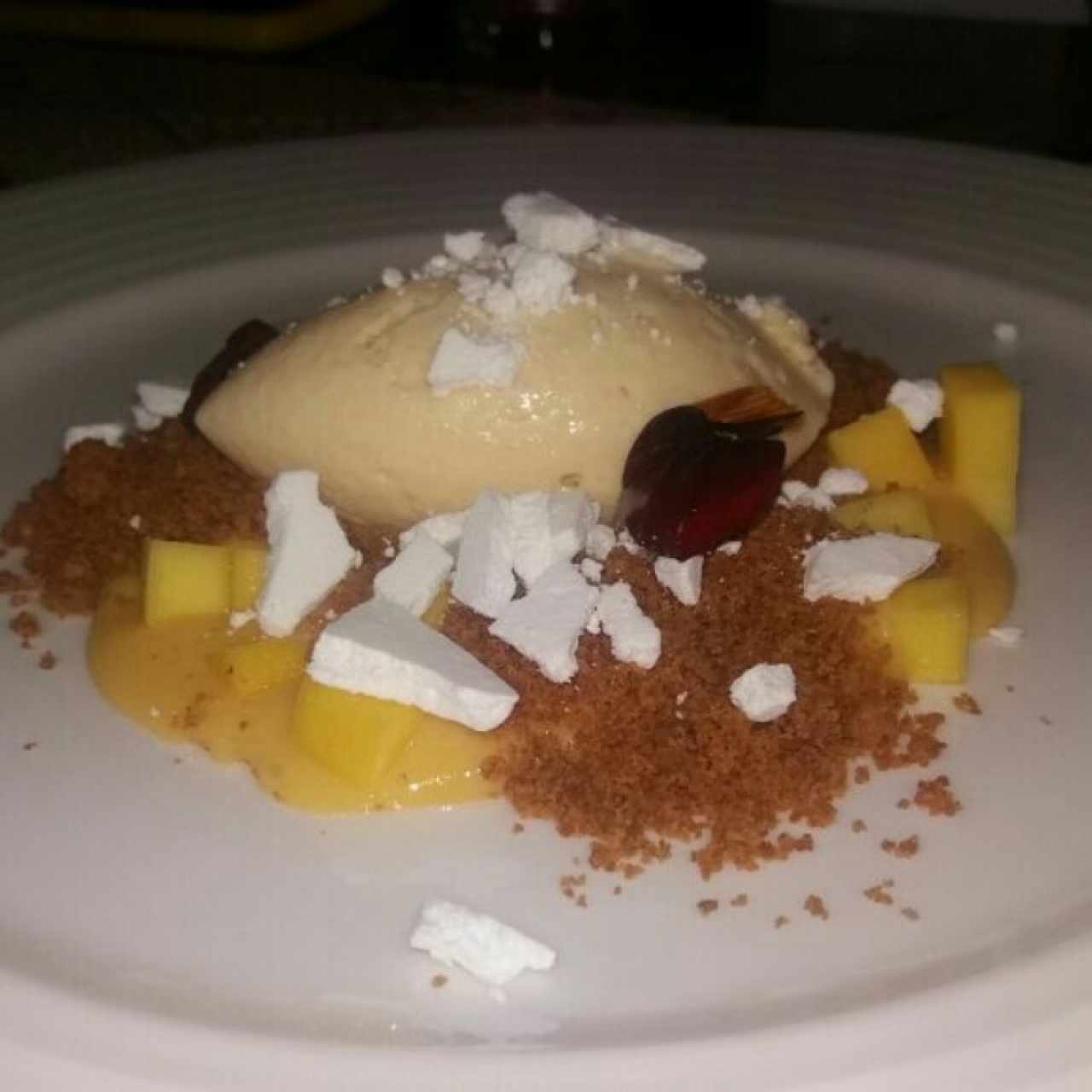 Exotic - Postre, salsa de maracuya con trozos de mango y merengue, galletas graham y helado de coco.