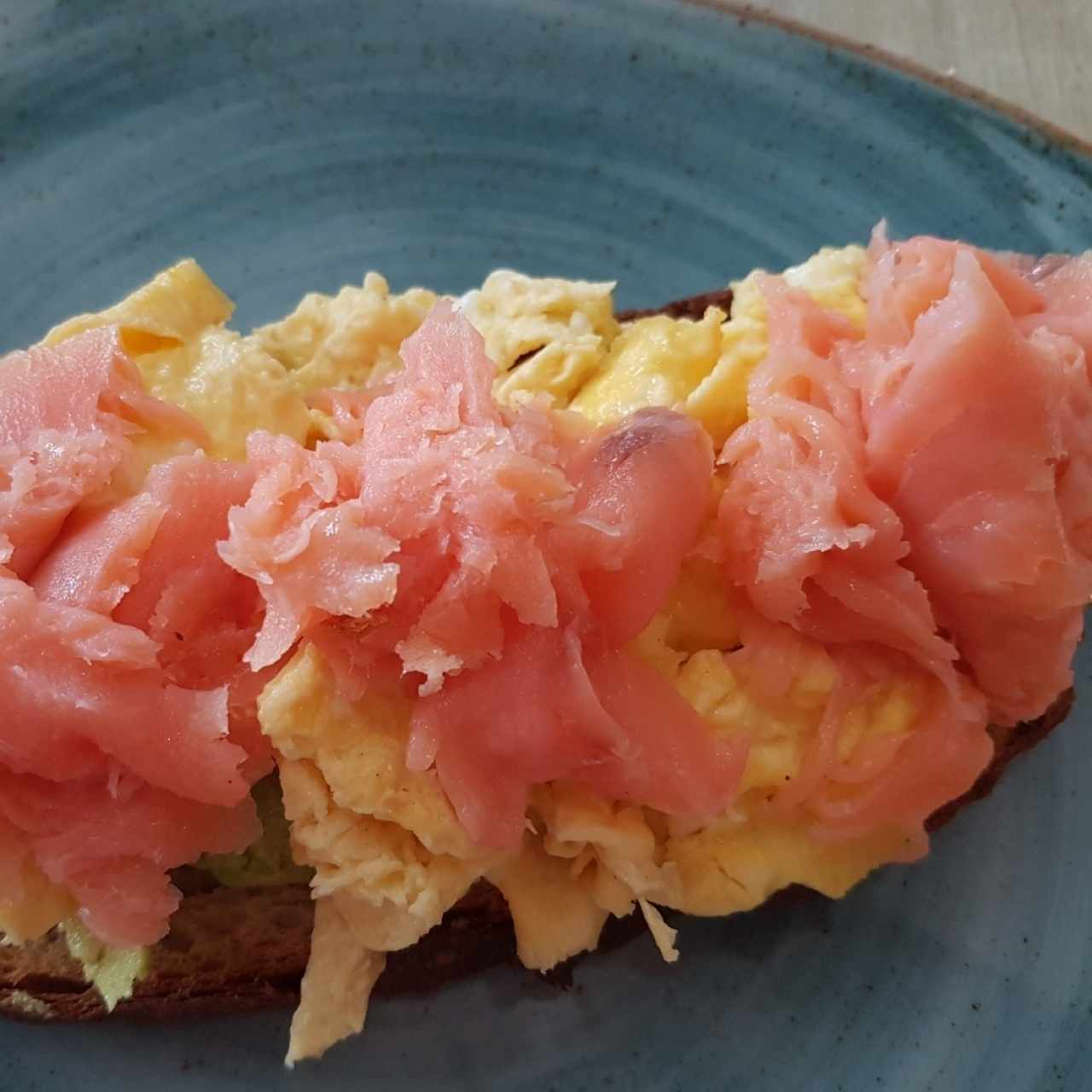 salmon huevo y aguacate sobre pan tostado