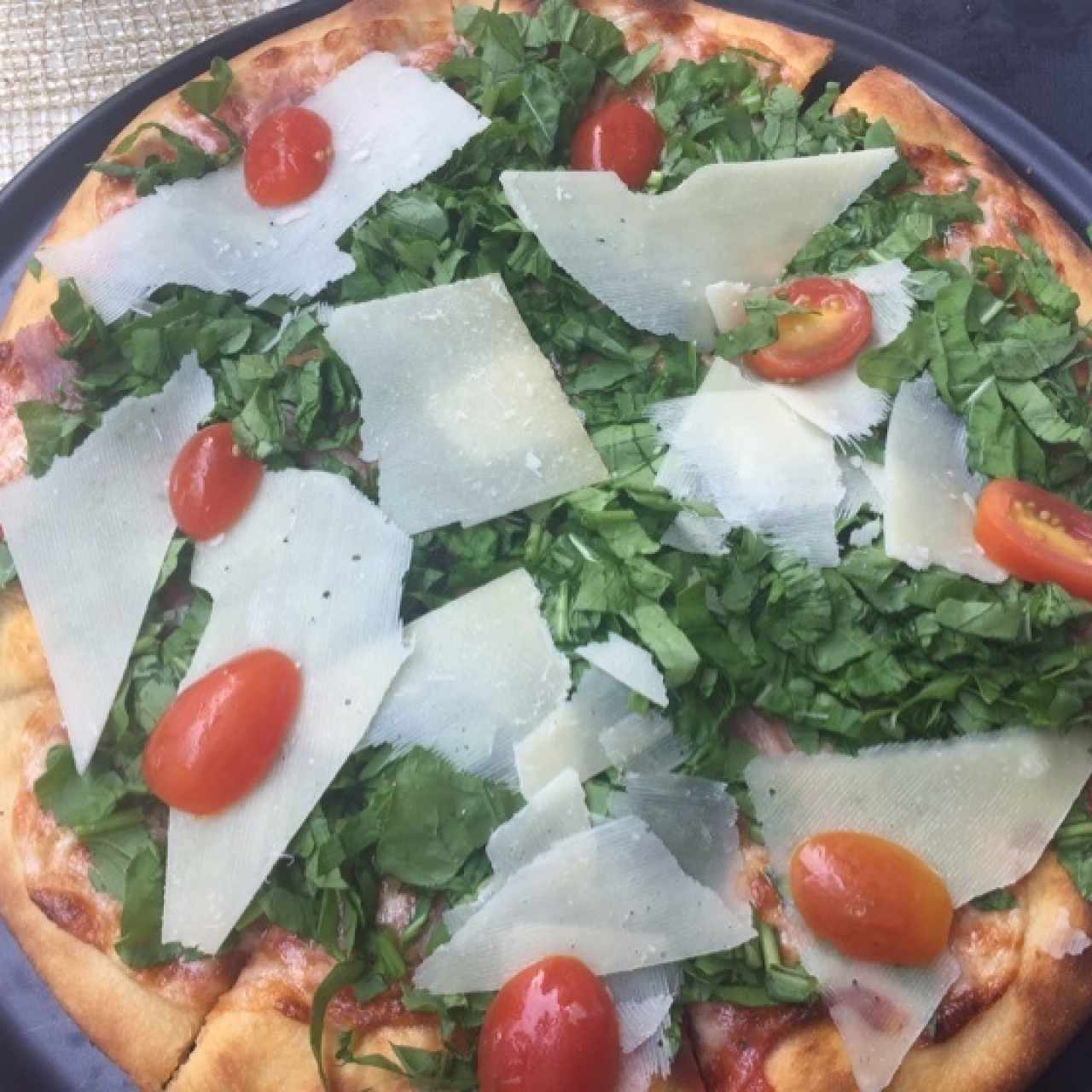 pizza de rugula parmesano y tomates cherry  