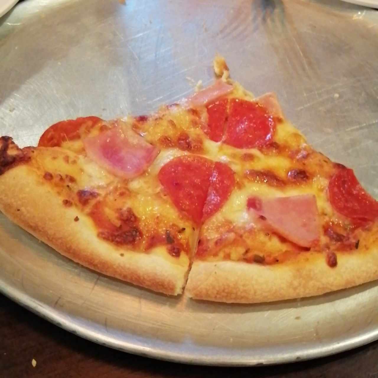 pizza artesanal de peperoni y jamon. 
