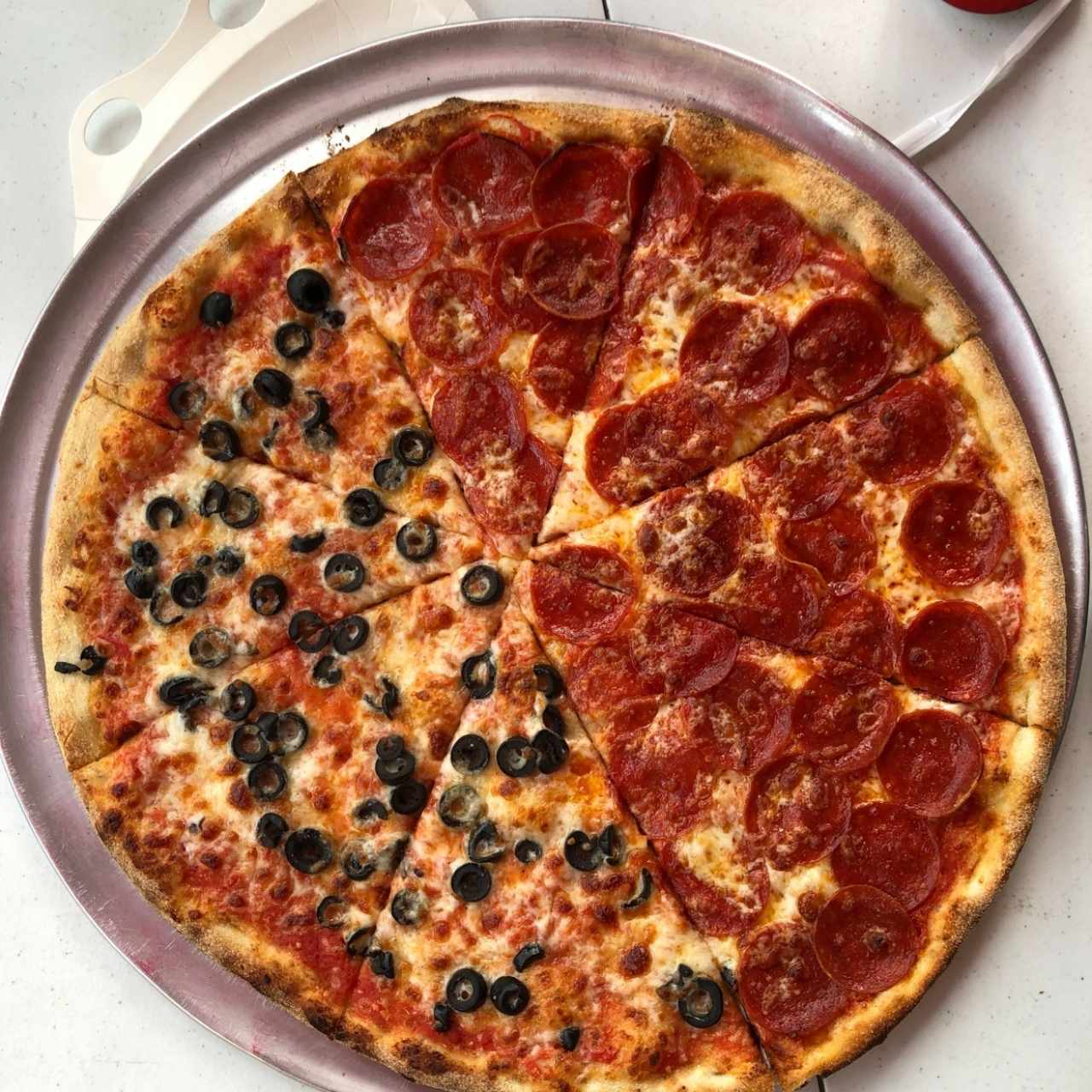 deliciosa pizza mitad peperoni y mitad aceitunas negras en Katané