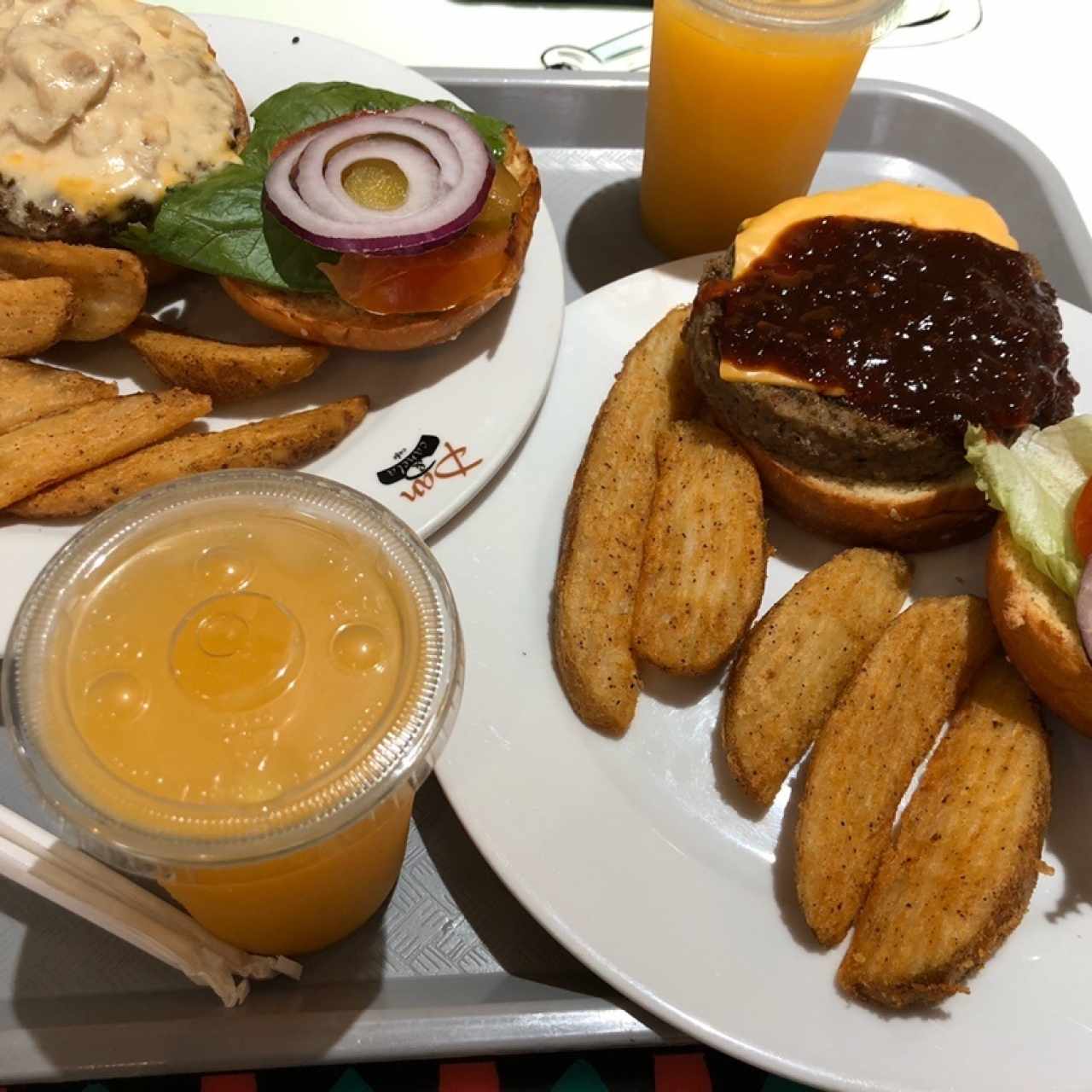 Hamburguesas BBQ y Champi-queso con jugos de naranja.