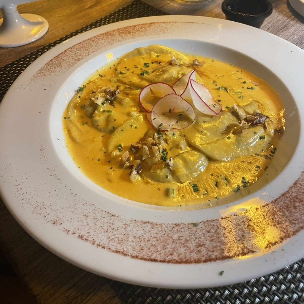 Ravioli relleno de langostino y crema de la casa 