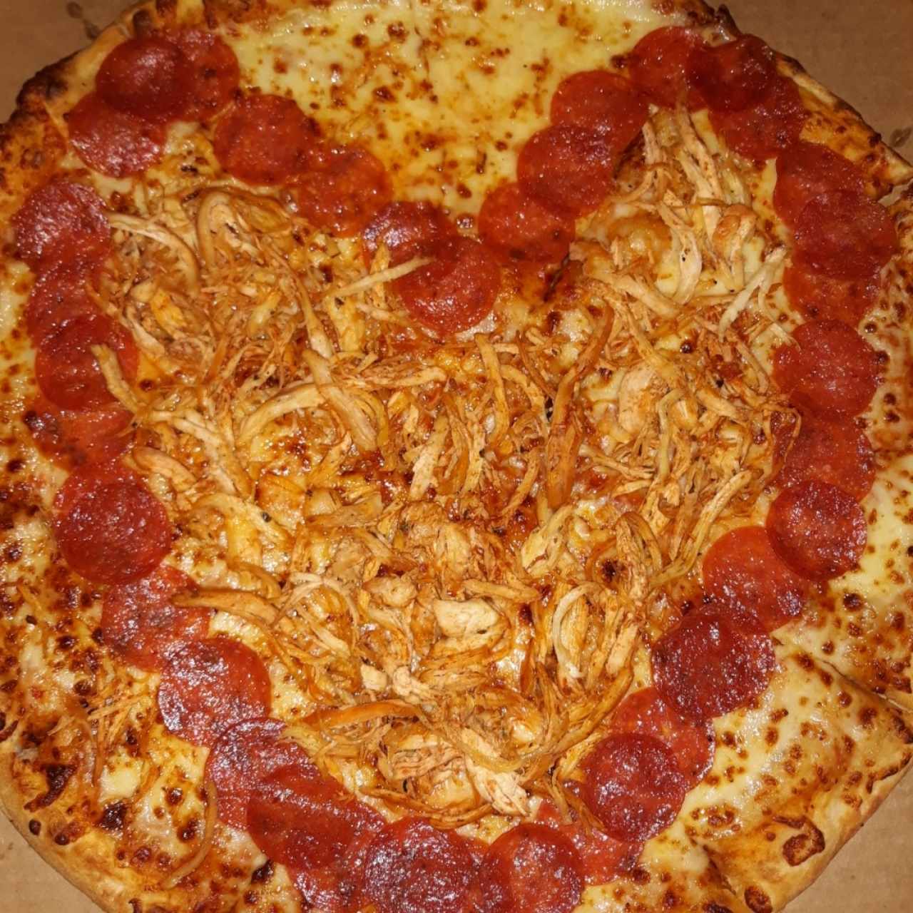 Pizza de peperoni y pollo con decoración de corazón 