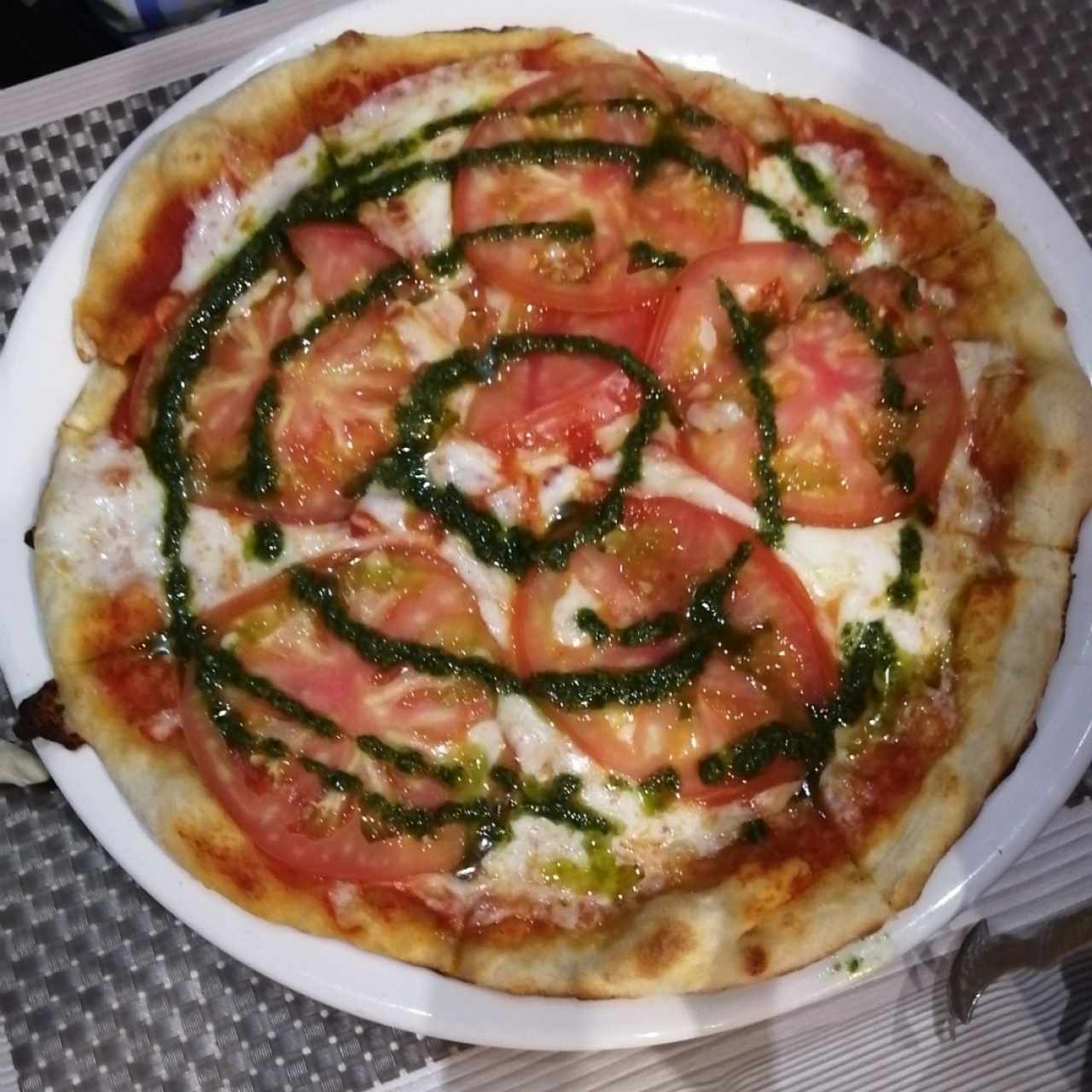 Pizza de tomate con pesto. 