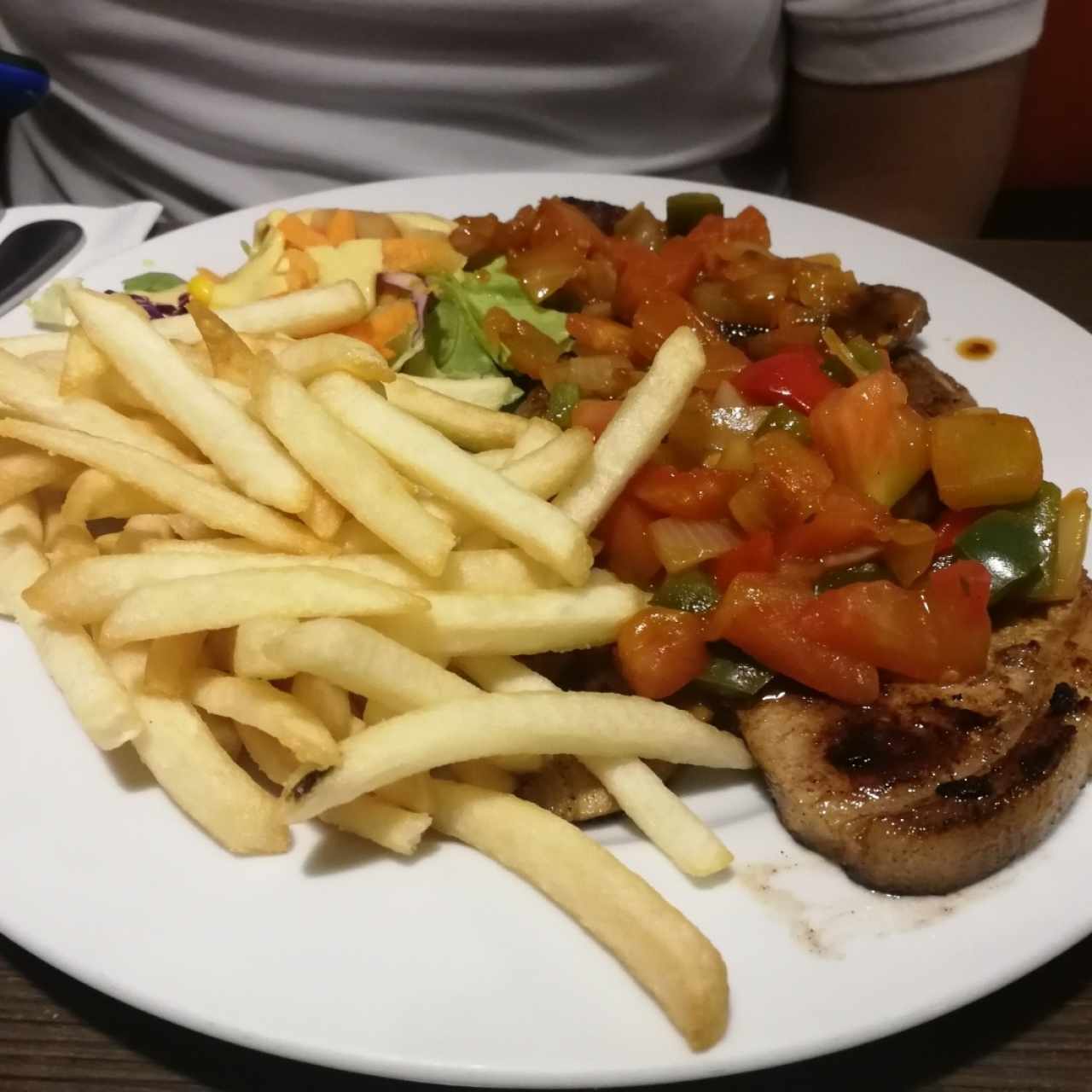 Chuleta de cerdo en salsa criolla con papas fritas