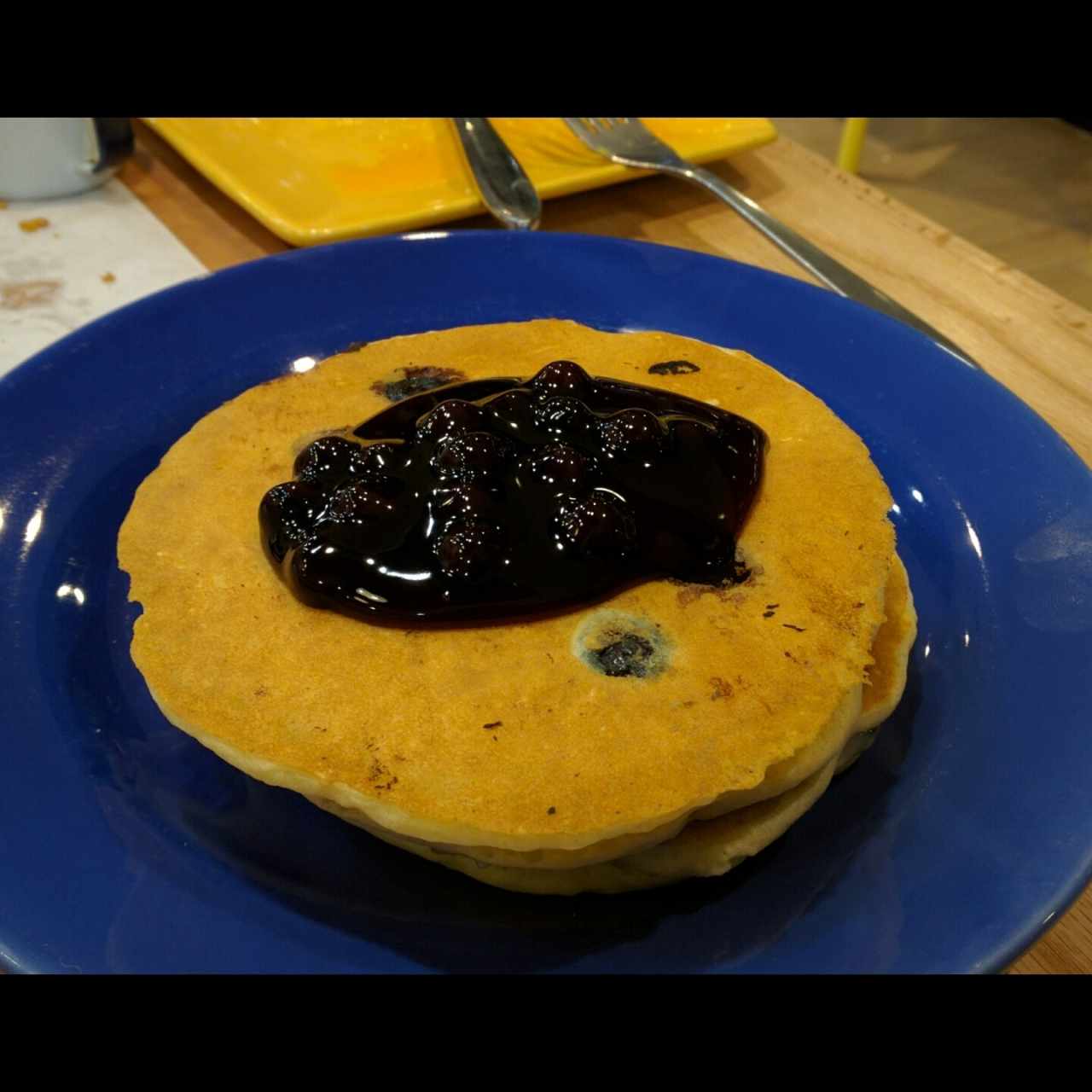 blueberry pancakes con huellas de dedos en el plato