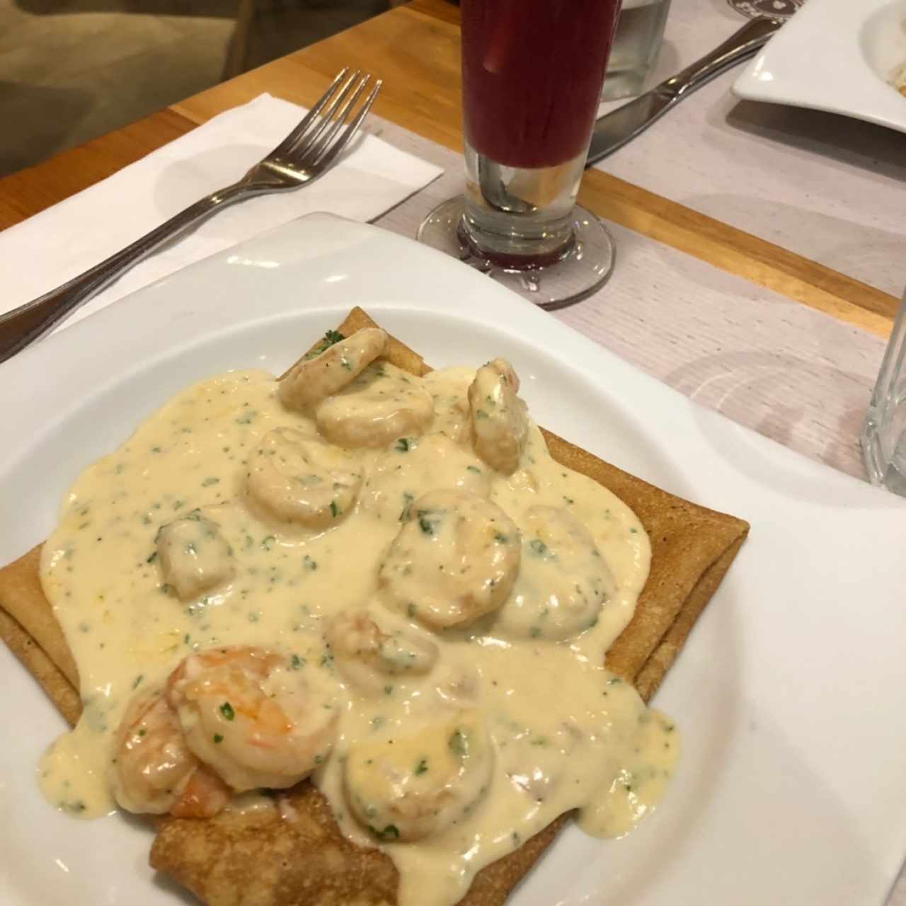 Crepe de camarones al ajillo con jugo de moras.