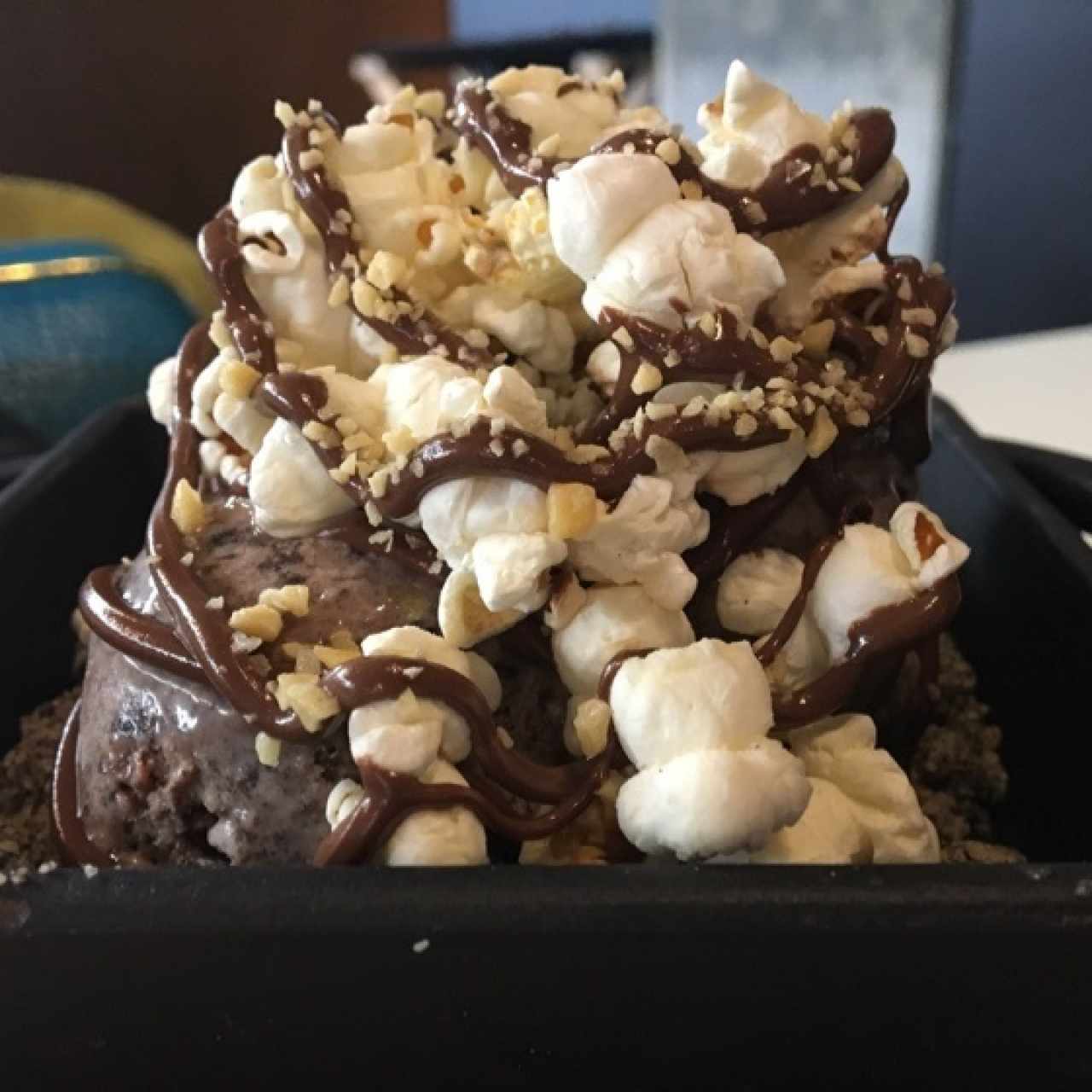 helado de chocolate, sobre una cama de oreo y galleta cubriera con popcorn 