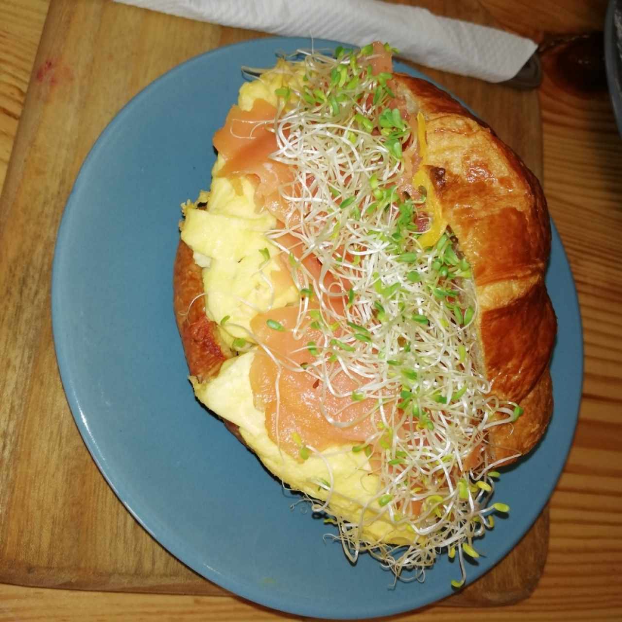 Emparedado Criminal en pan croissant huevo, salmón y aguacate