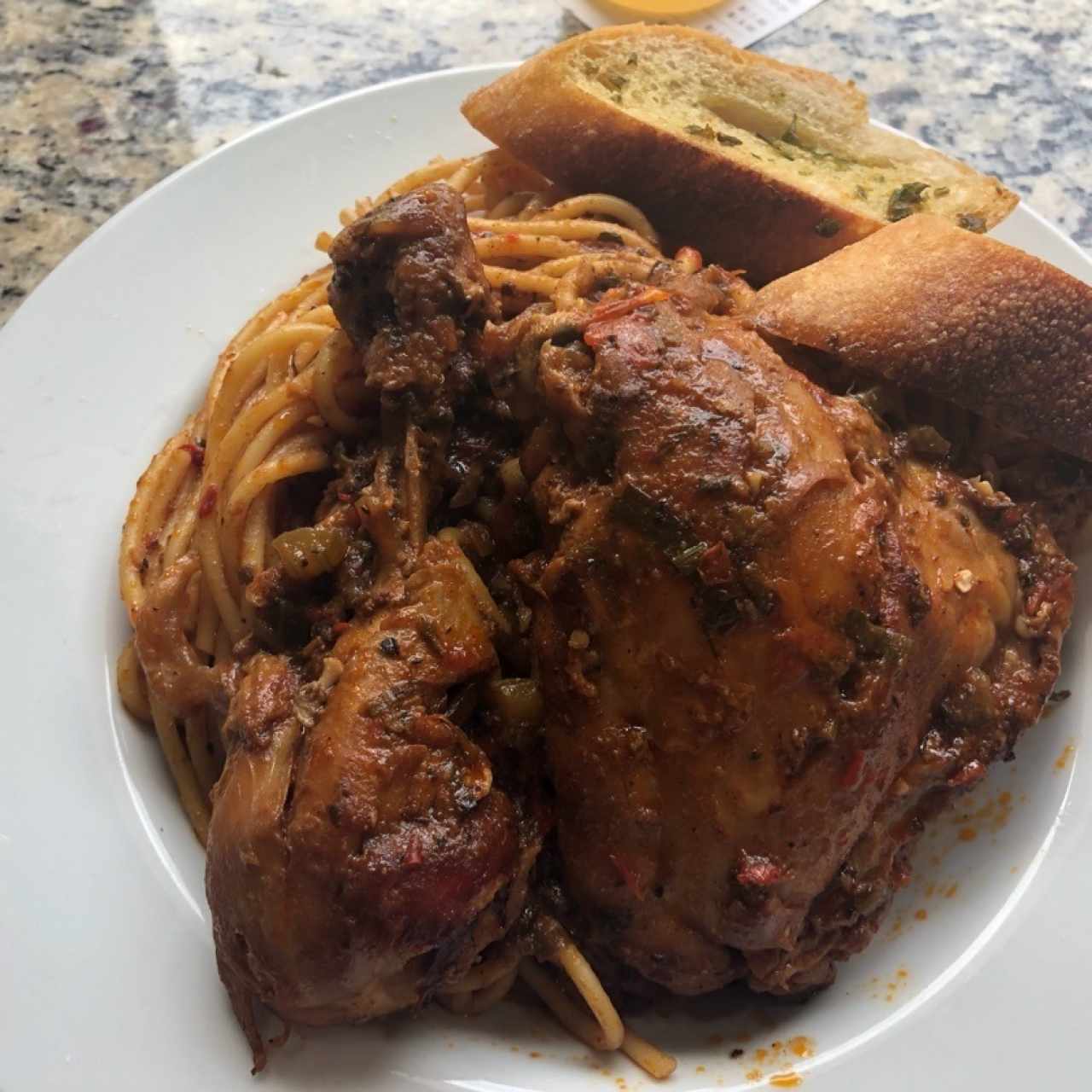 spaghetti con pollo en salsa roja y pan