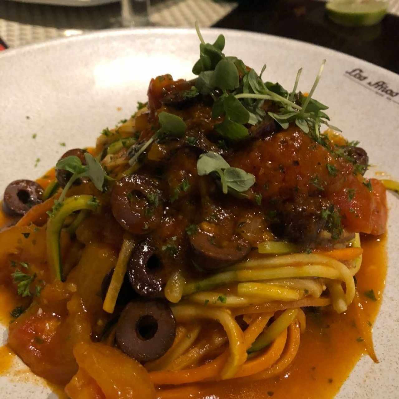 Spaghettini de zuchini y zanahoria con salsa pomodoro y aceitunas kalamata