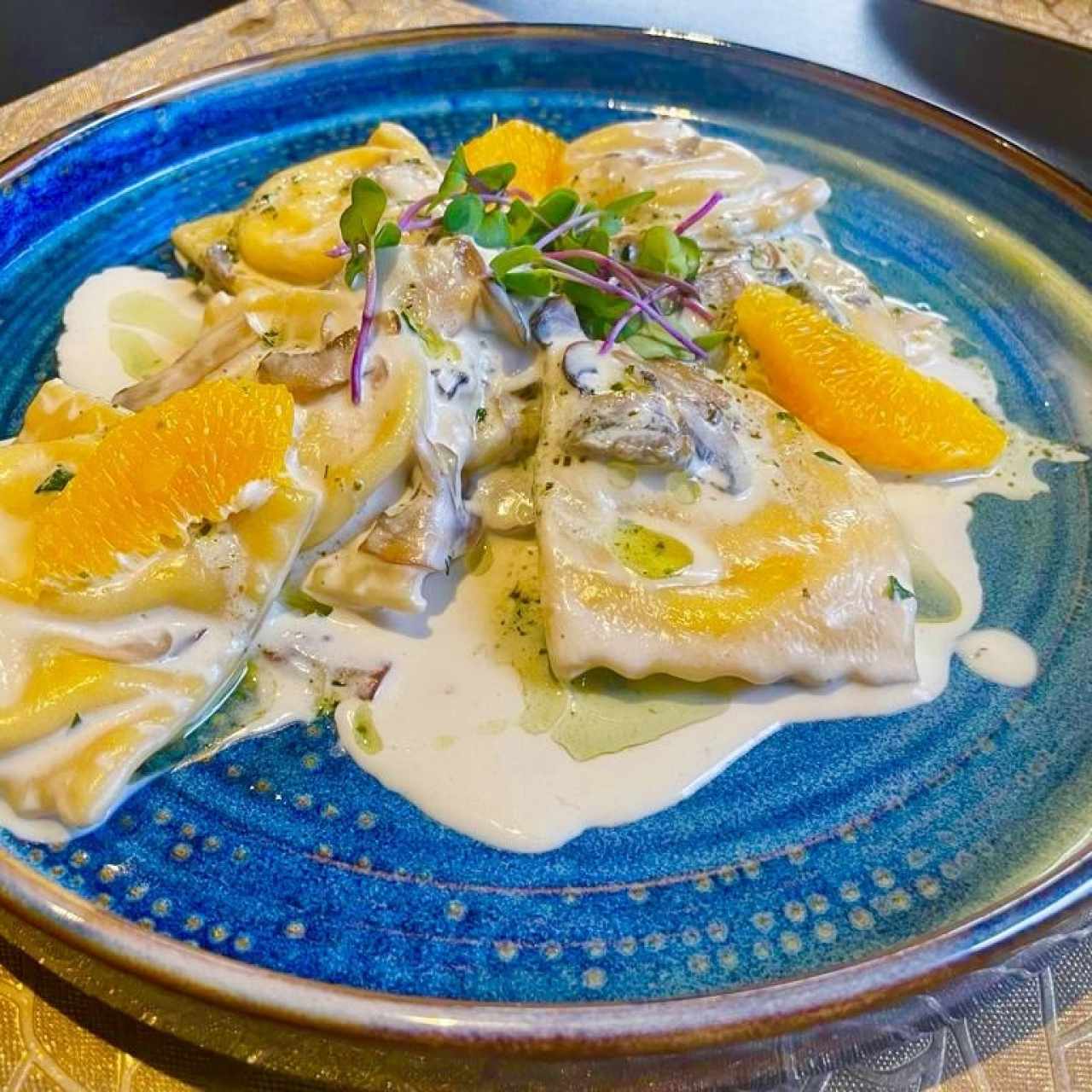 RAVIOLIS DE SALMÓN (Ravioli Clásico hecho en Casa, Crema , Champiñones y  Vino Blanco, coronados con Supremas de Naranja, Tartar de Vegetales, Almendras Fileteadas y Pesto de Albahaca)