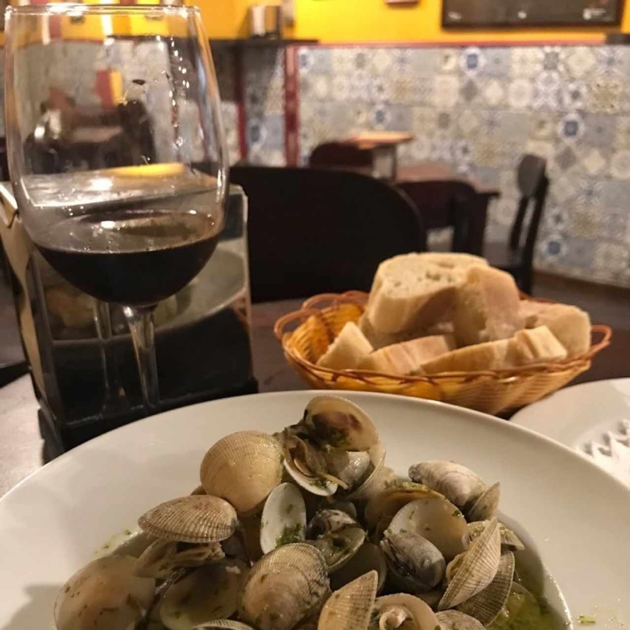 vino tinto, pan de la casa y almejas al ajillo