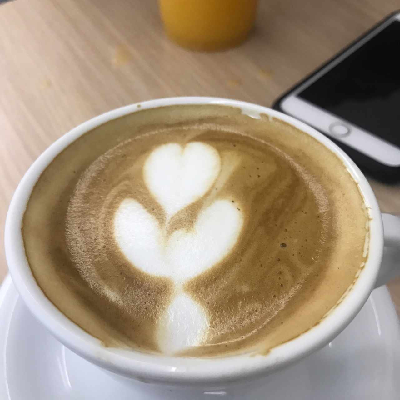 capuccino y al fondo jugo de naranja