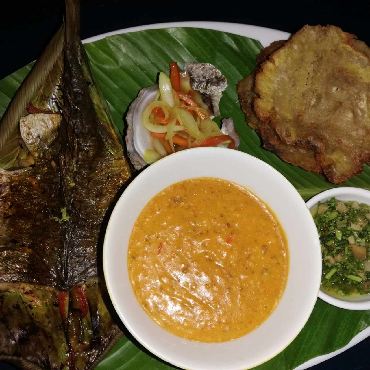 Pescado de corvina, acompañado de patacones y Tamal de olla