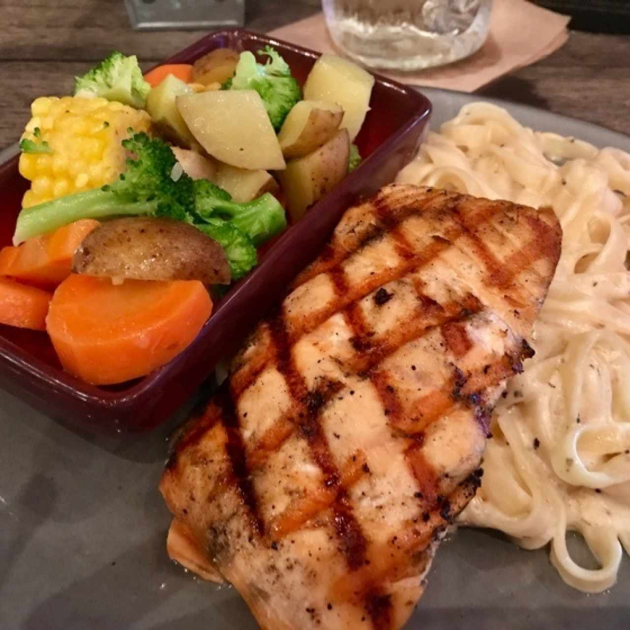 Salmón, pasta alfredo y vegetales al vapor