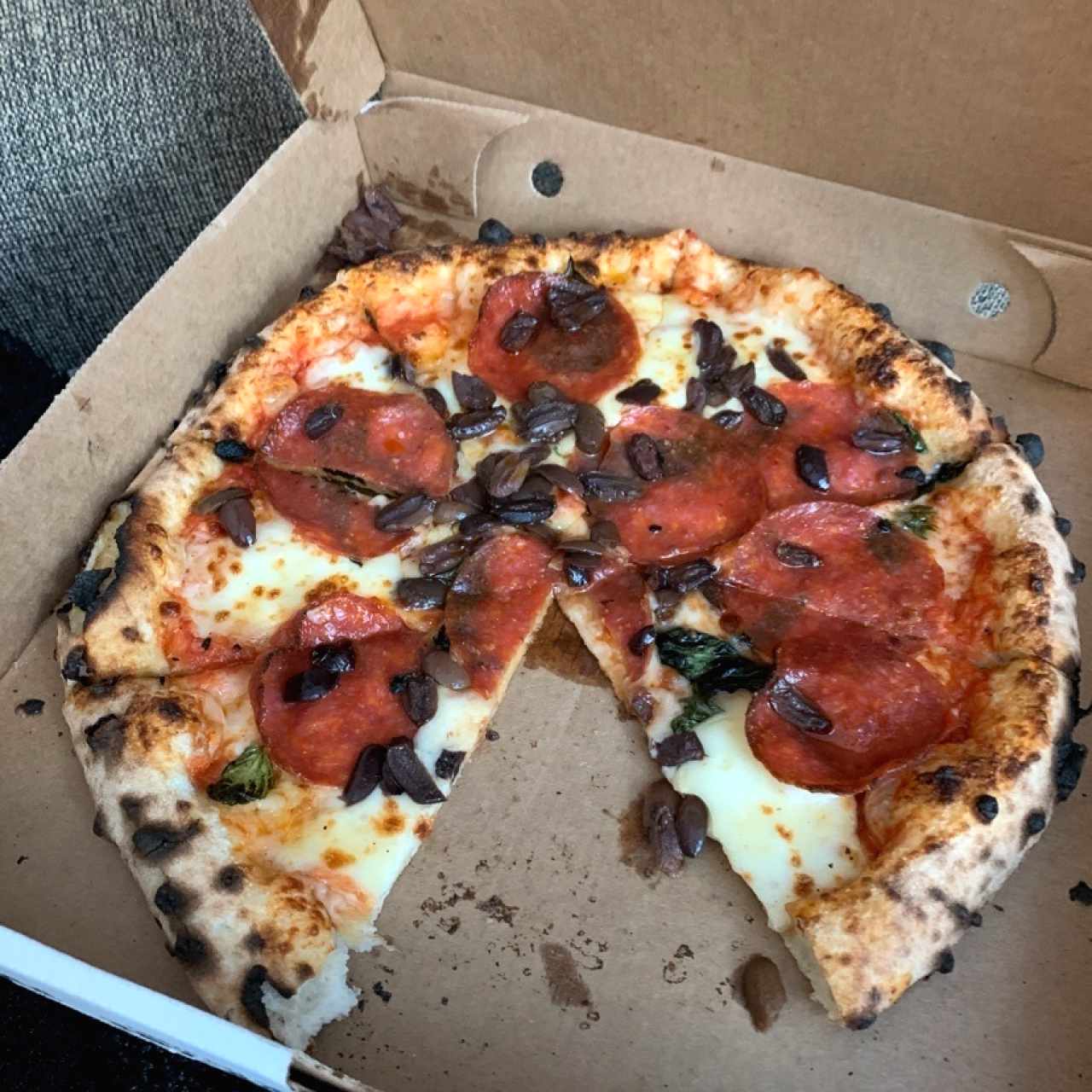 pizza de pepperoni, black olives, albahaca y miel picante