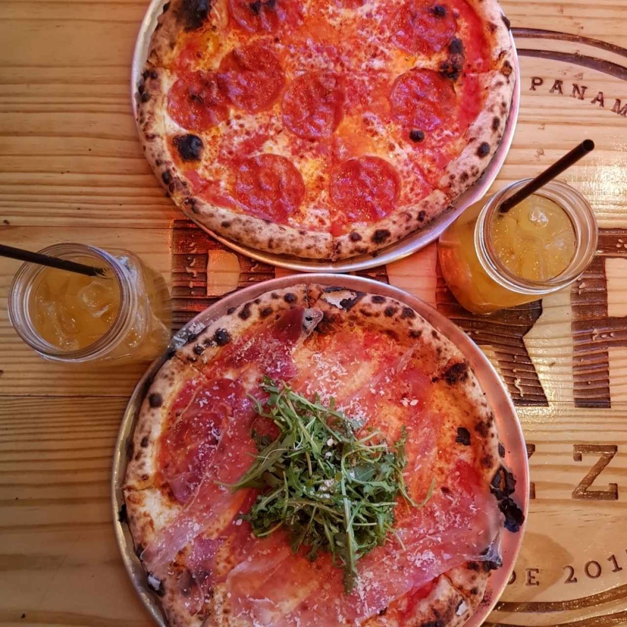 Pizza de pepperoni, pizza "La Yeyesita" y bebidas de maracuyá con raspadura.