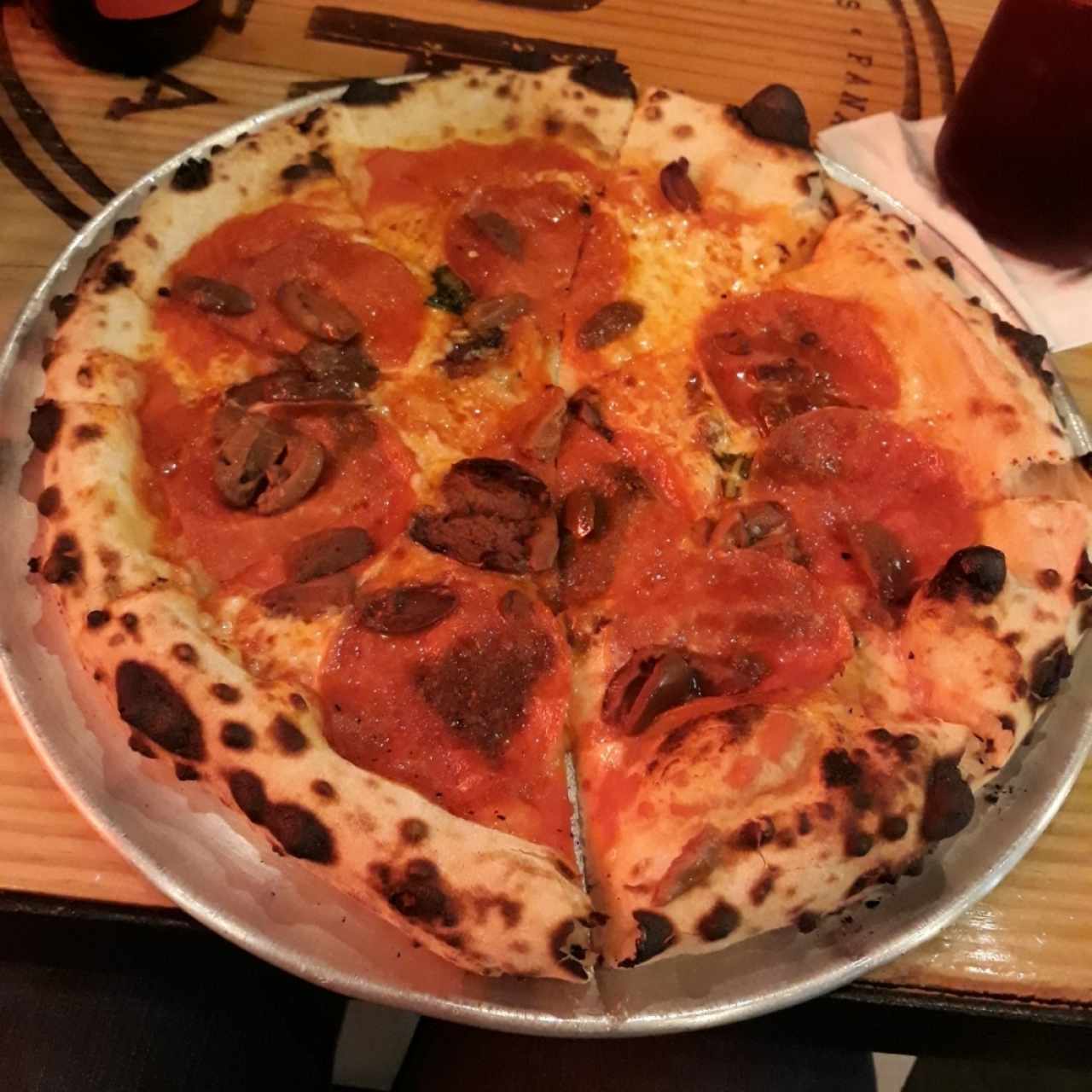 Pizza de pepperoni, albahaca y aceitunas negras