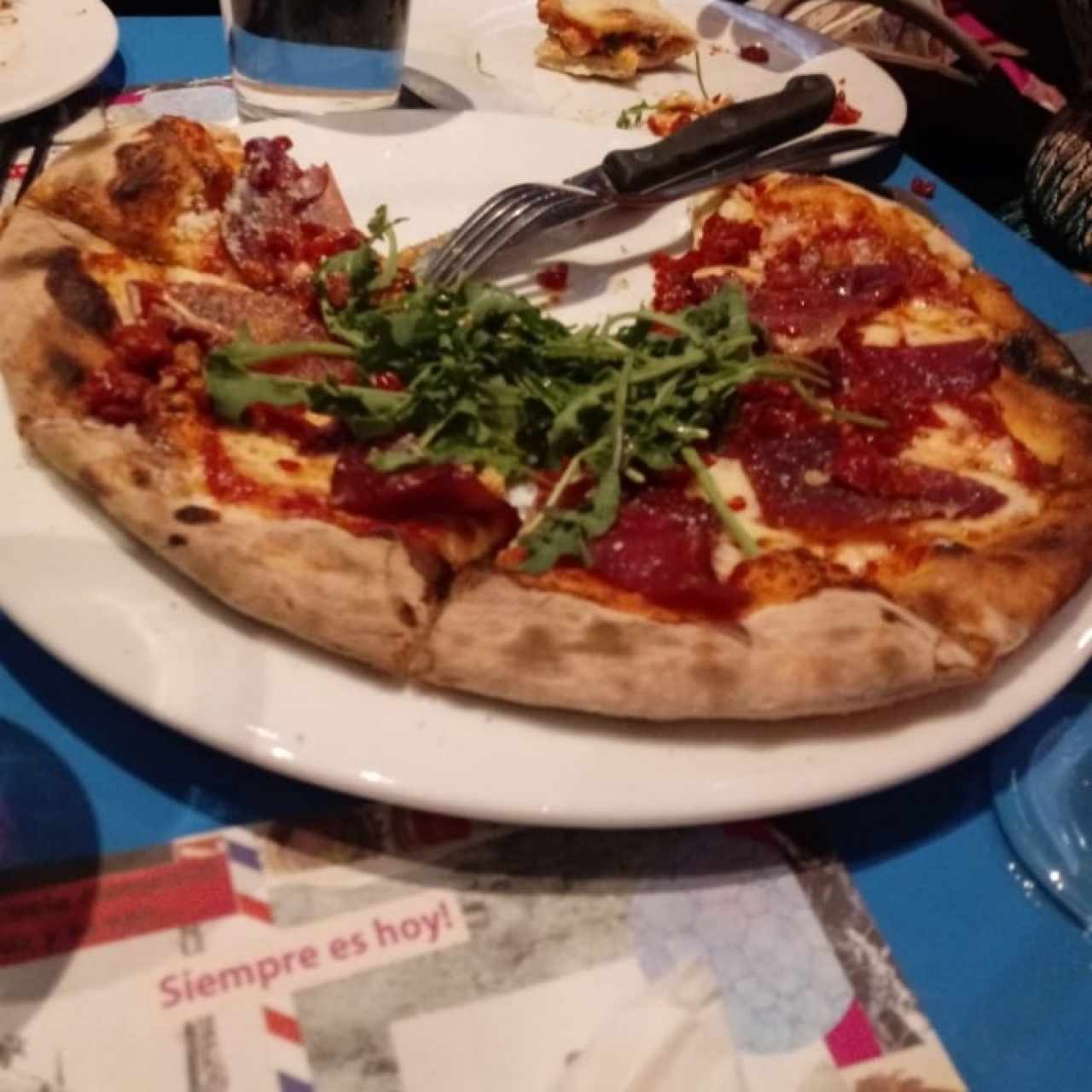 Pizza de pepperoni con rúcula.
