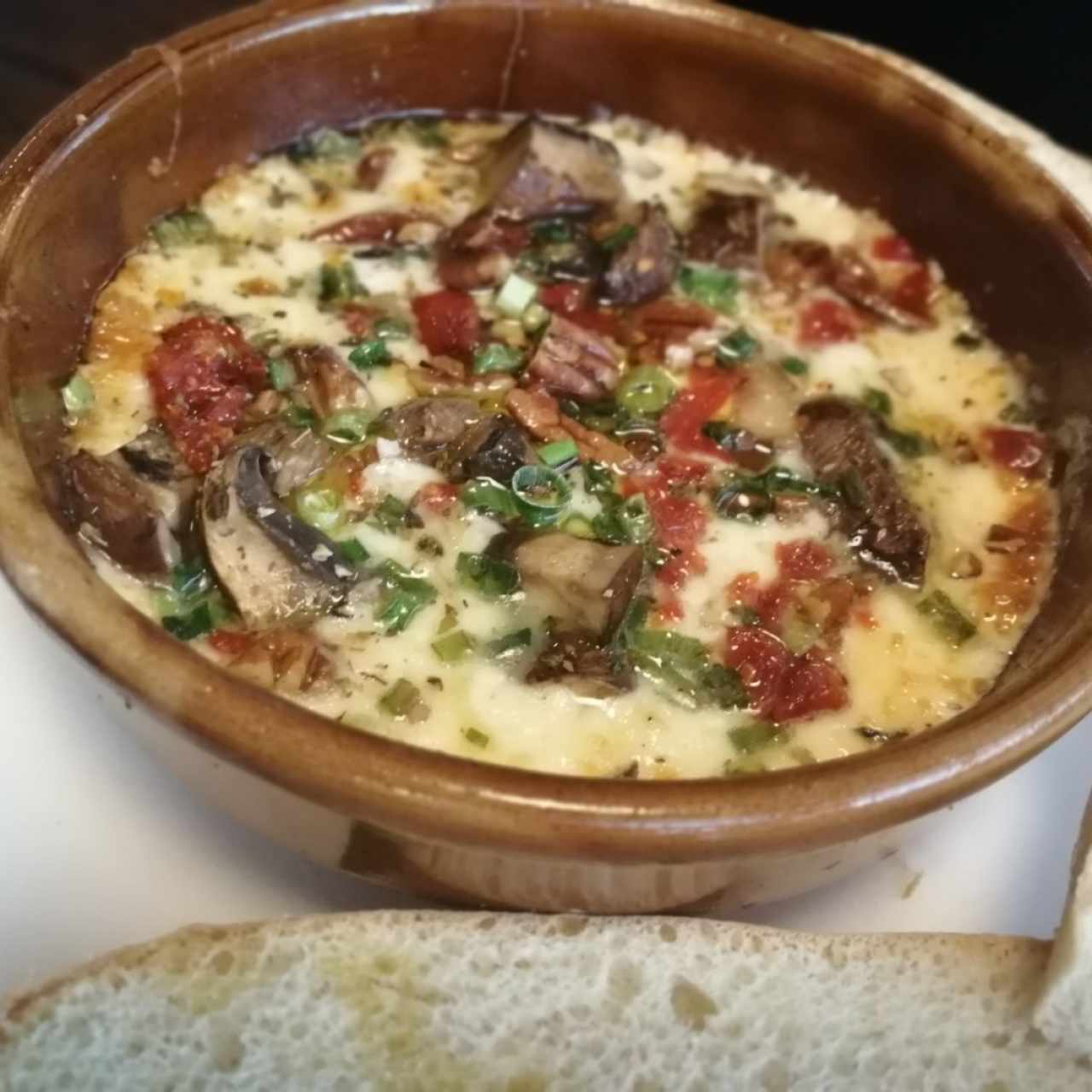 Provolone derretido con Portobello, tomates secos, pecanas y cebollín servido con tostadas