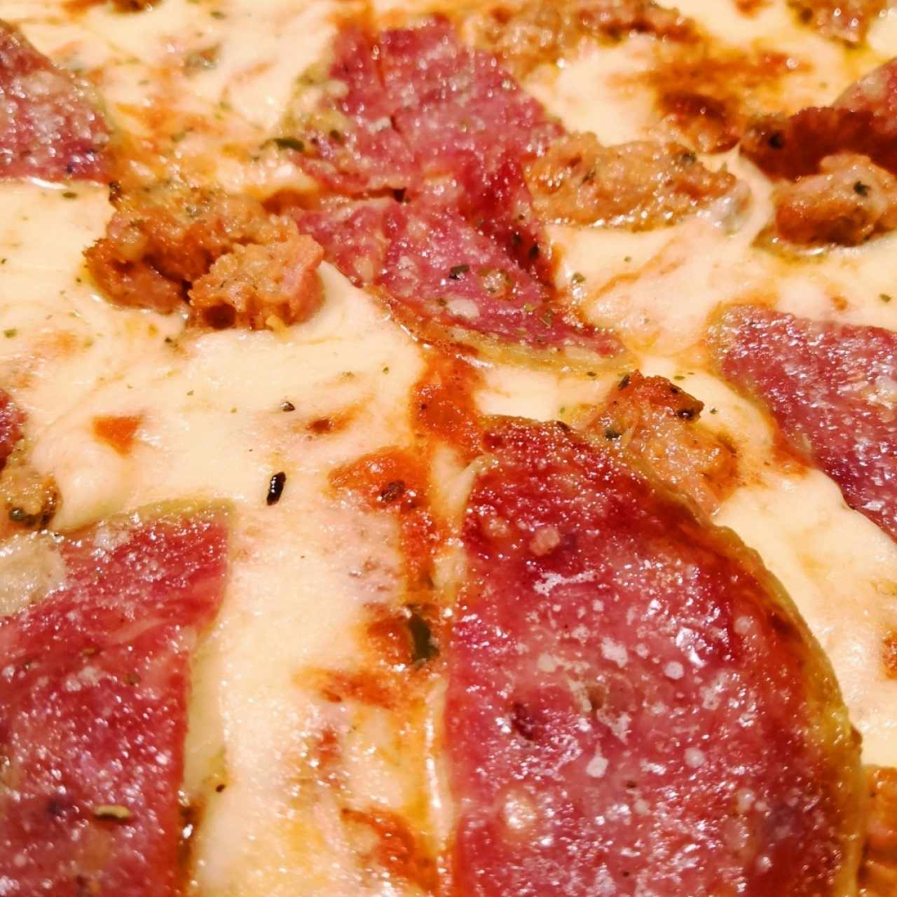 Detalle de la pizza de salami y salchicha italiana