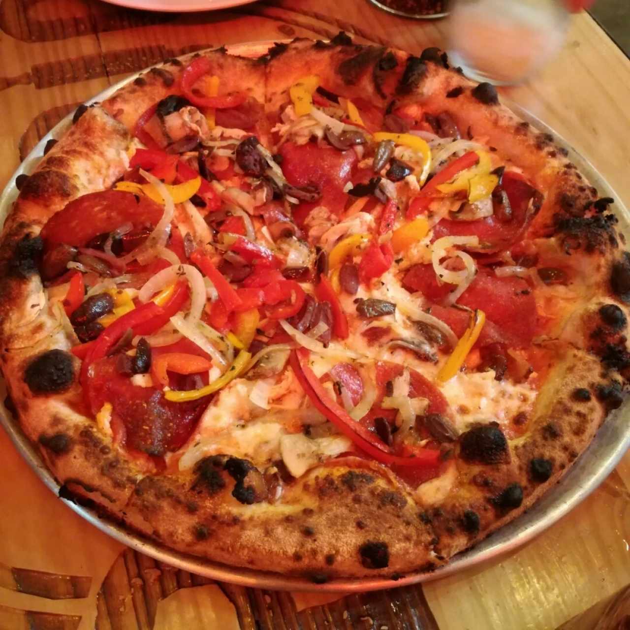 Barrio pizza con extra de aceitunas, pepperoni y cebolla