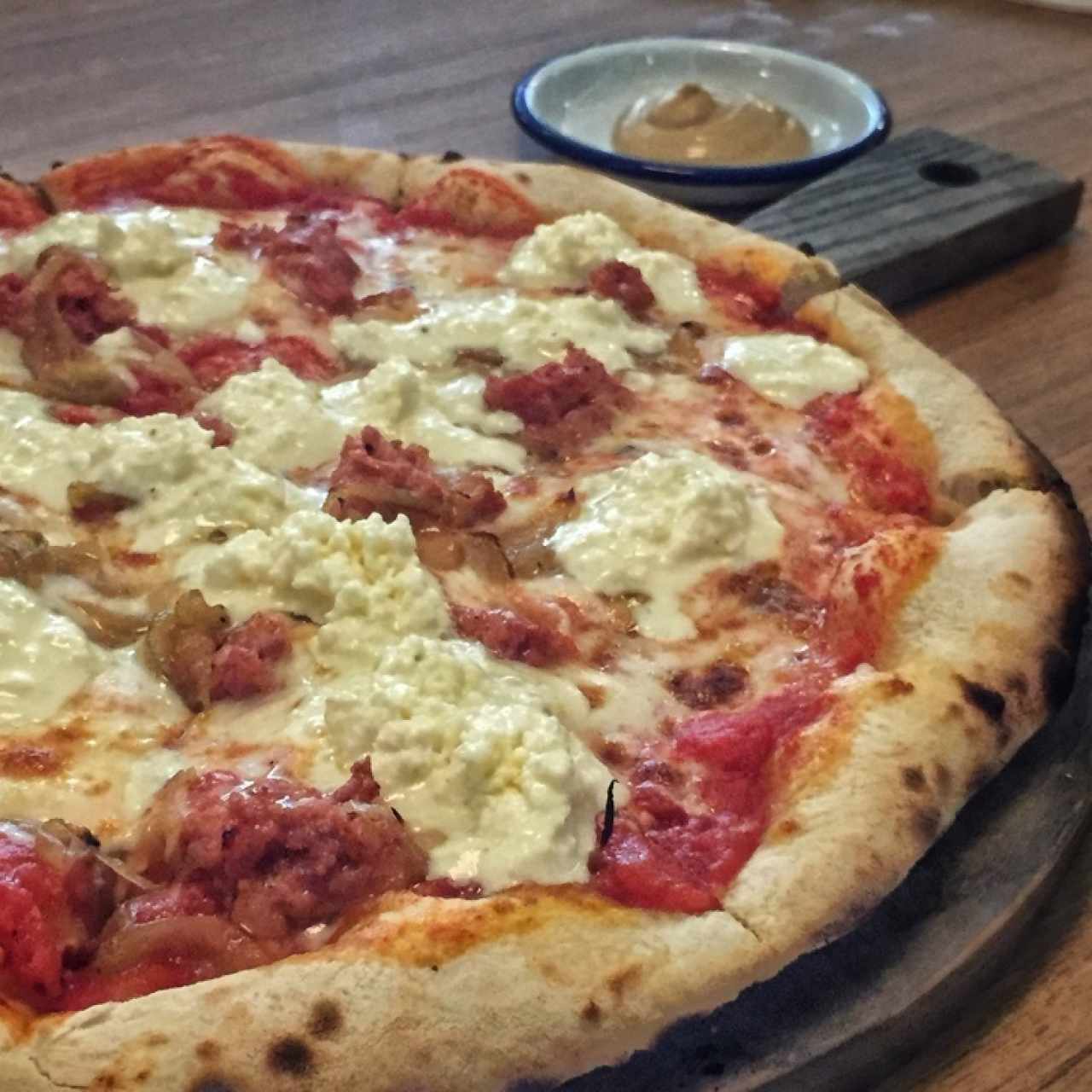 Pizza La Centrale...salsiccia, salsa pomodoro, queso de cabra, cebolla frita, mozzarella y straciatella