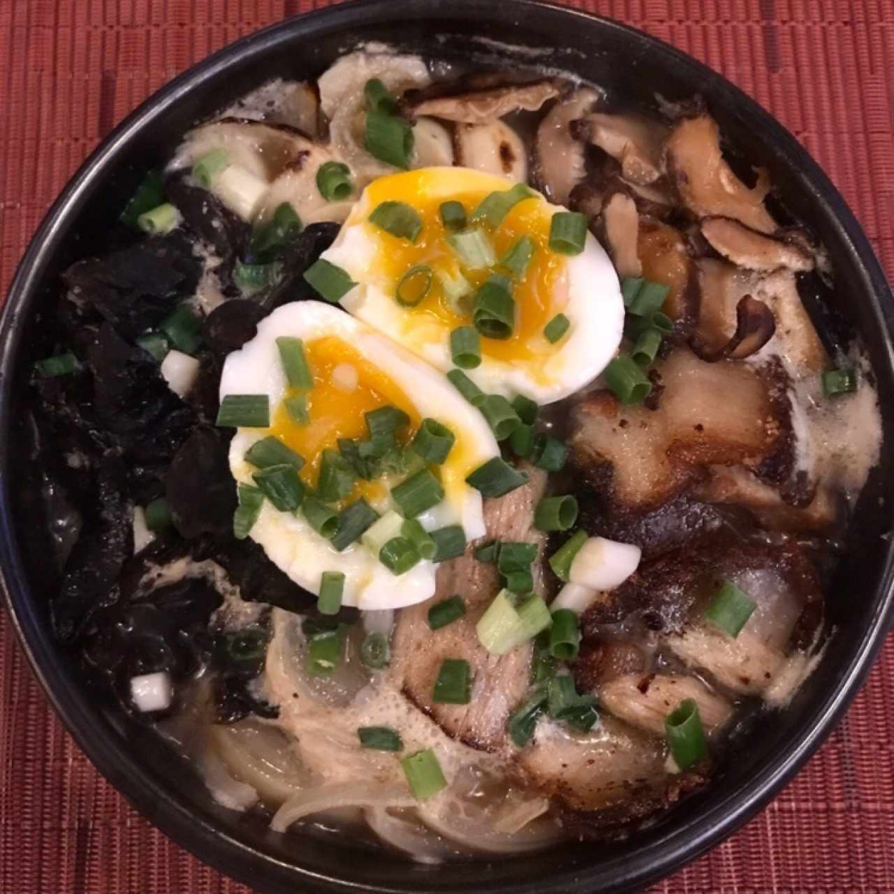 Bossam Ramyun Sopa de ramyun con puerco (bossam), cebollita, cebolla, hongo enoki, hongo negro, huevo, berro y ajo.
